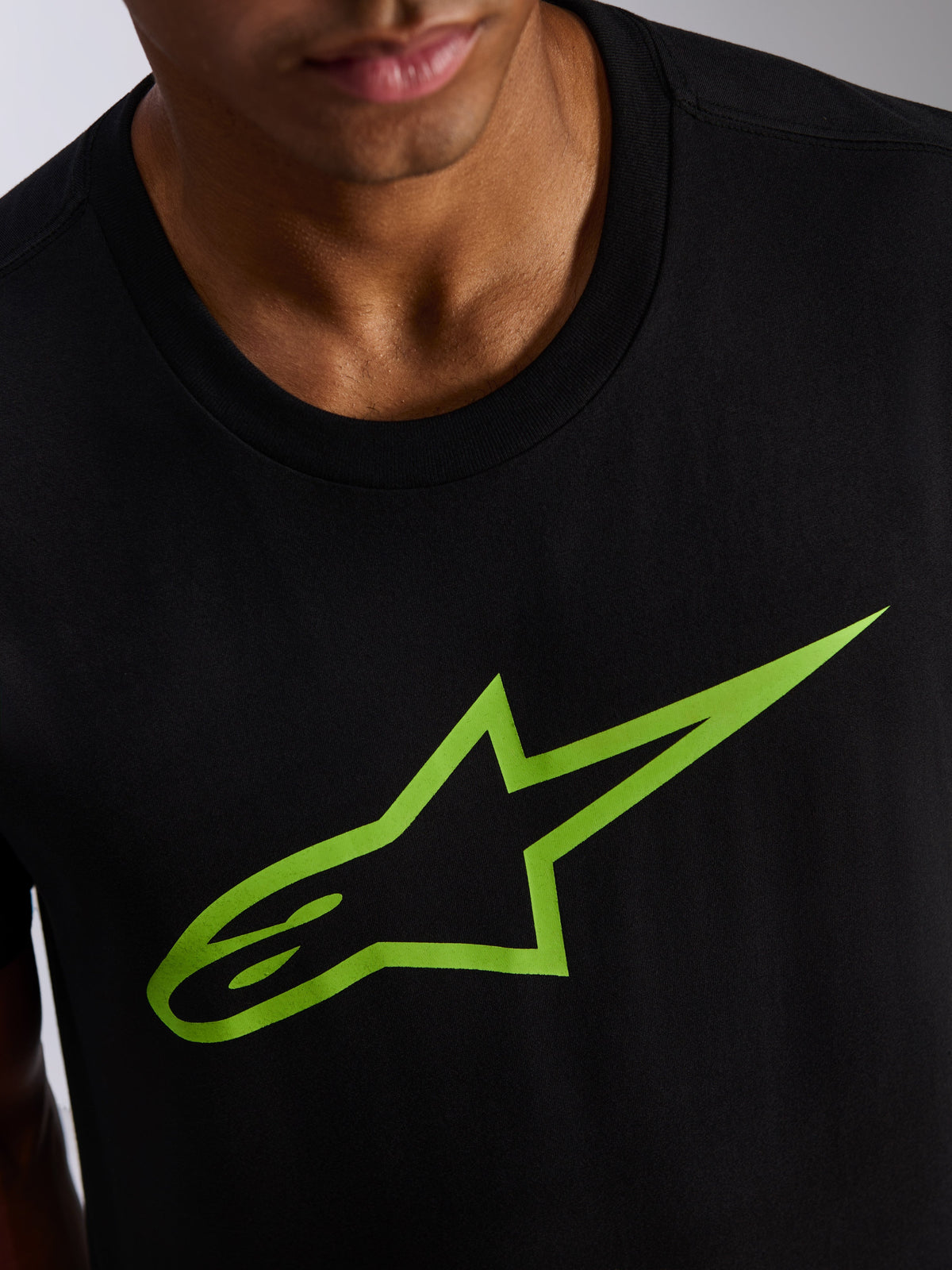 Alpinestars Ageless 2.0 CSF Tee, Kurzarm-T-Shirt, Schwarz mit leuchtend grünem Stern-Logo, Nahaufnahme von Brustgrafik und Ausschnitt, lässige Motorsport-Streetwear