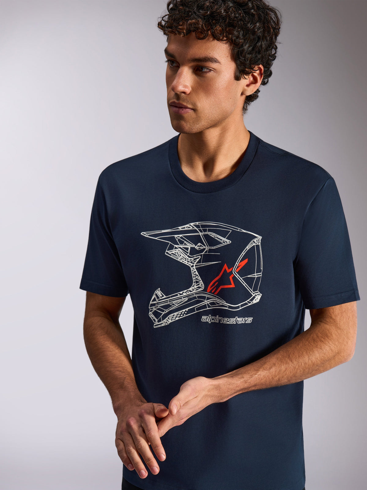 Alpinestars MX Helmet CSF Tee, Kurzarm-T-Shirt, Dunkelblau, weiße MX-Helm-Grafik mit einem roten Stern-Logo, lässige Sportbekleidung, getragen von einem Model