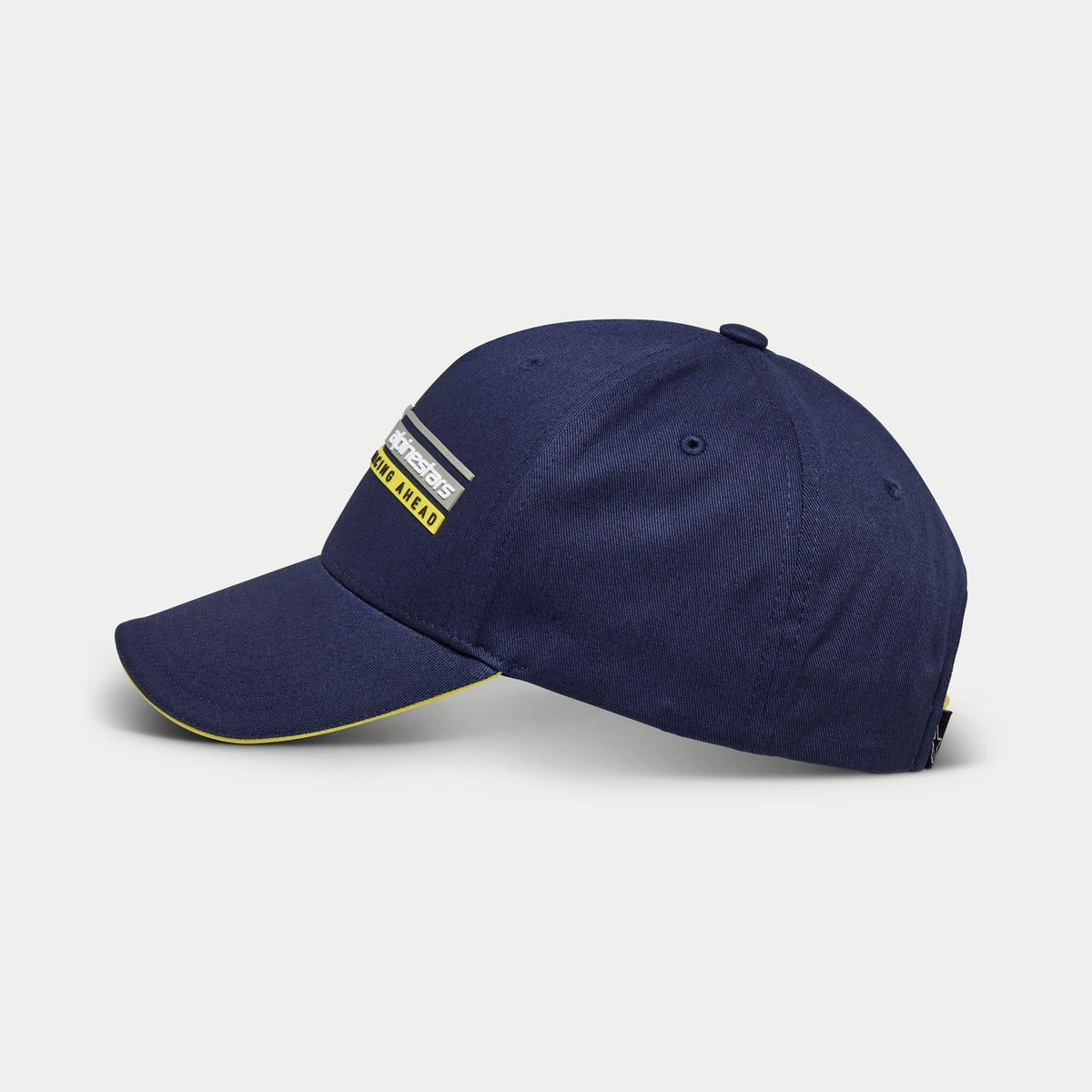 Alpinestars Par Hat, Navy Blue Baseball Cap, side view, structured crown with curved bill and yellow sandwich detail, Alpinestars Racing Ahead linear logo 3D embroidery, casual motorsport-inspired headwear