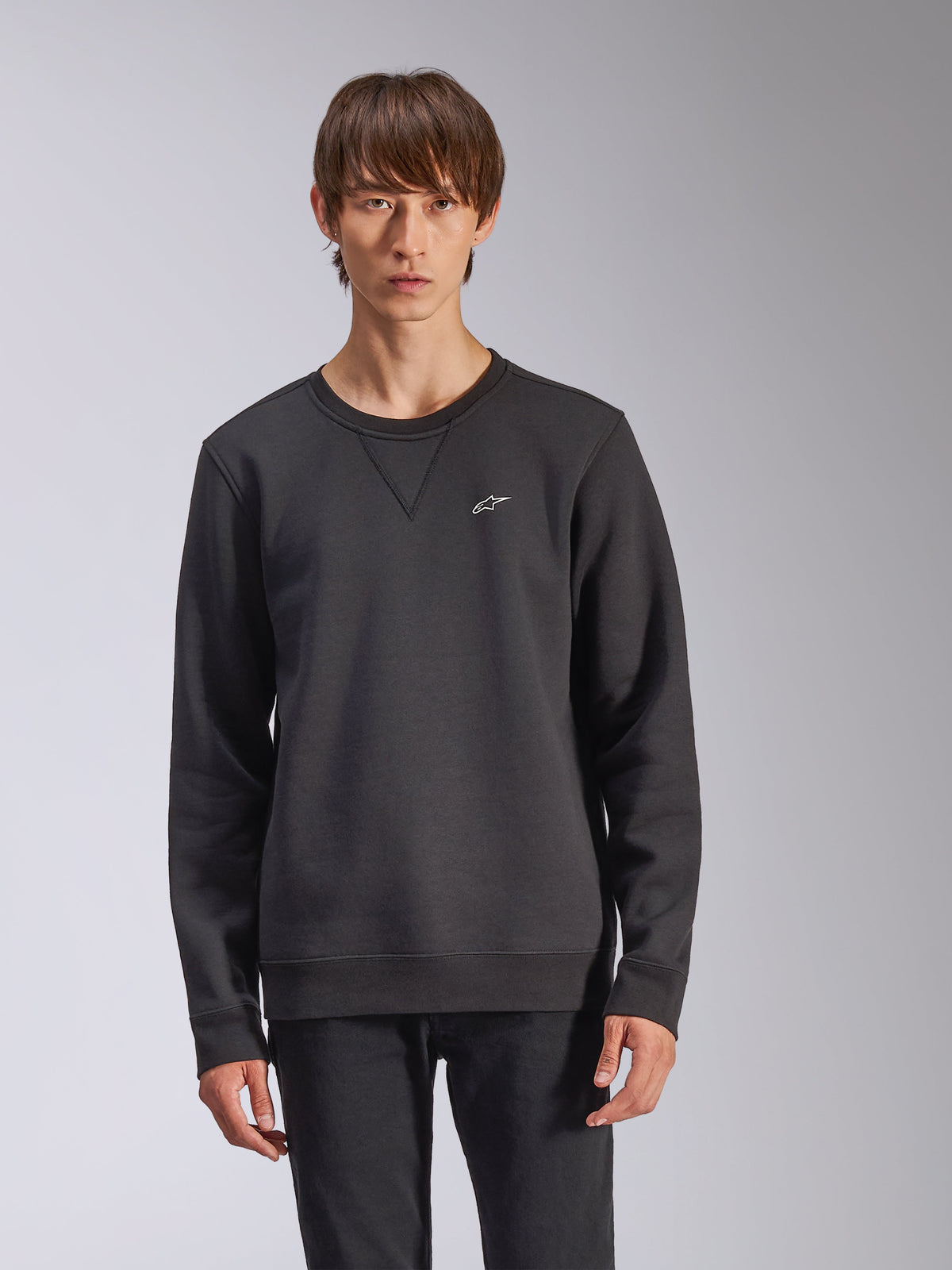 Alpinestars Positive Crew Sweatshirt, schwarz, mit kleinem weißem Alpinestars-Sternlogo auf der Brust, V-Stich-Detail am Rundhalsausschnitt, gerippte Bündchen und Saum, lässige vom Motorsport inspirierte Streetwear
