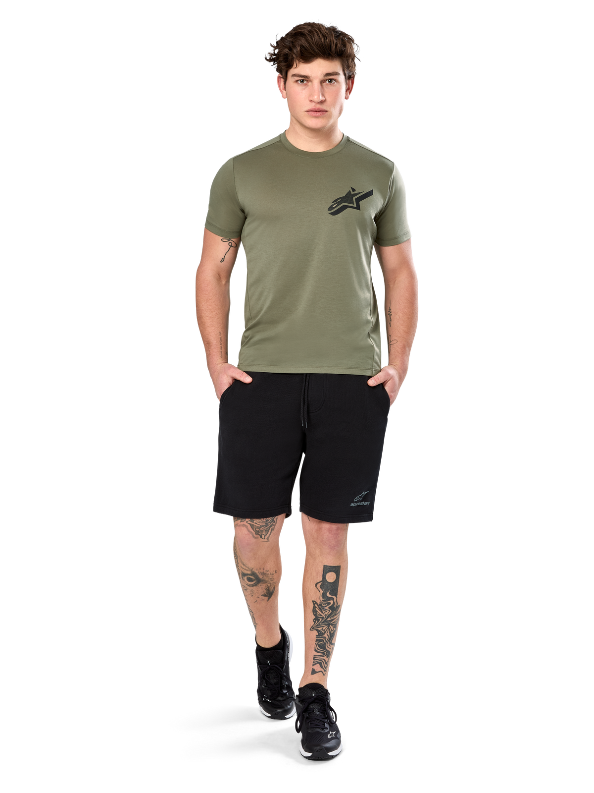 Alpinestars Attrition Performance Tee, Kurzarm-T-Shirt, Hellgrün, mit schwarzem Astars-Logo auf der Brust, getragen mit schwarzen Sport-Shorts und schwarzen Sneakern, Lifestyle-Aufnahme für funktionale Sportbekleidung