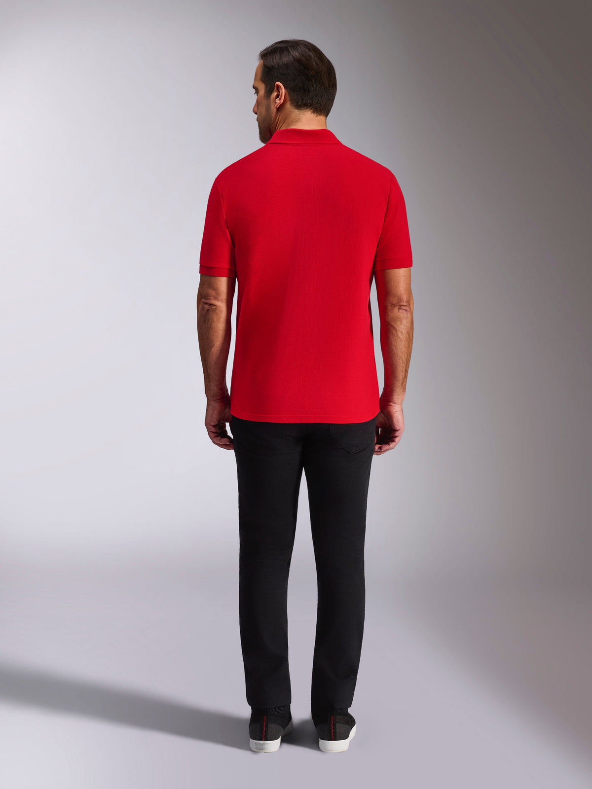 Alpinestars Endeavor Classic Polo, rotes Piqué-Poloshirt, Rückansicht, kombiniert mit einer schwarzen Hose, lässige Motorsport-Streetwear mit Rippkragen und Ärmelbündchen