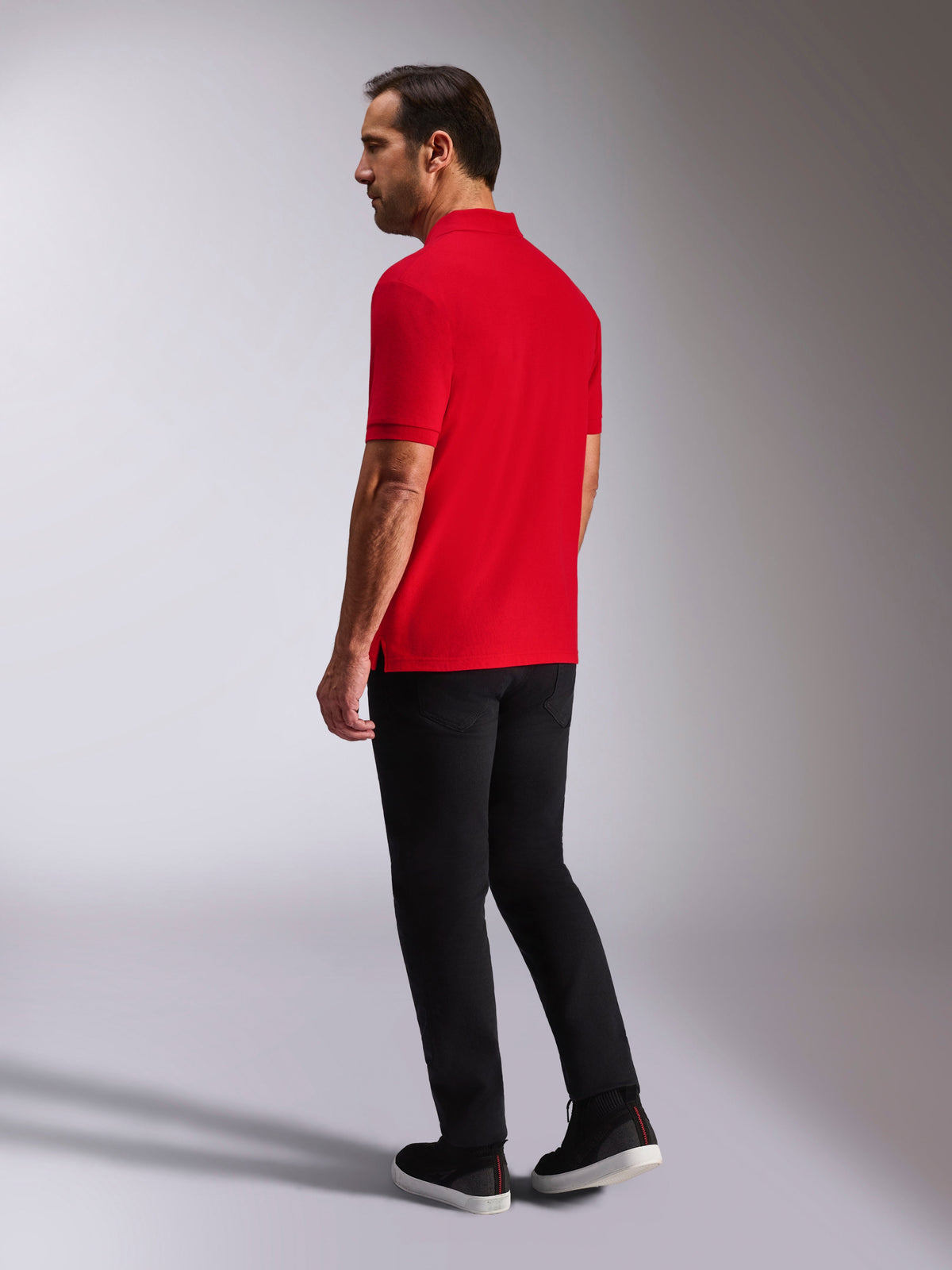 Alpinestars Endeavor Classic Polo, kurzärmeliges Piqué-Poloshirt, Rot, Rück- und Seitenansicht, mit Rippkragen und -bündchen, getragen mit schwarzer Hose und Schuhen, lässige, vom Motorsport inspirierte Streetwear