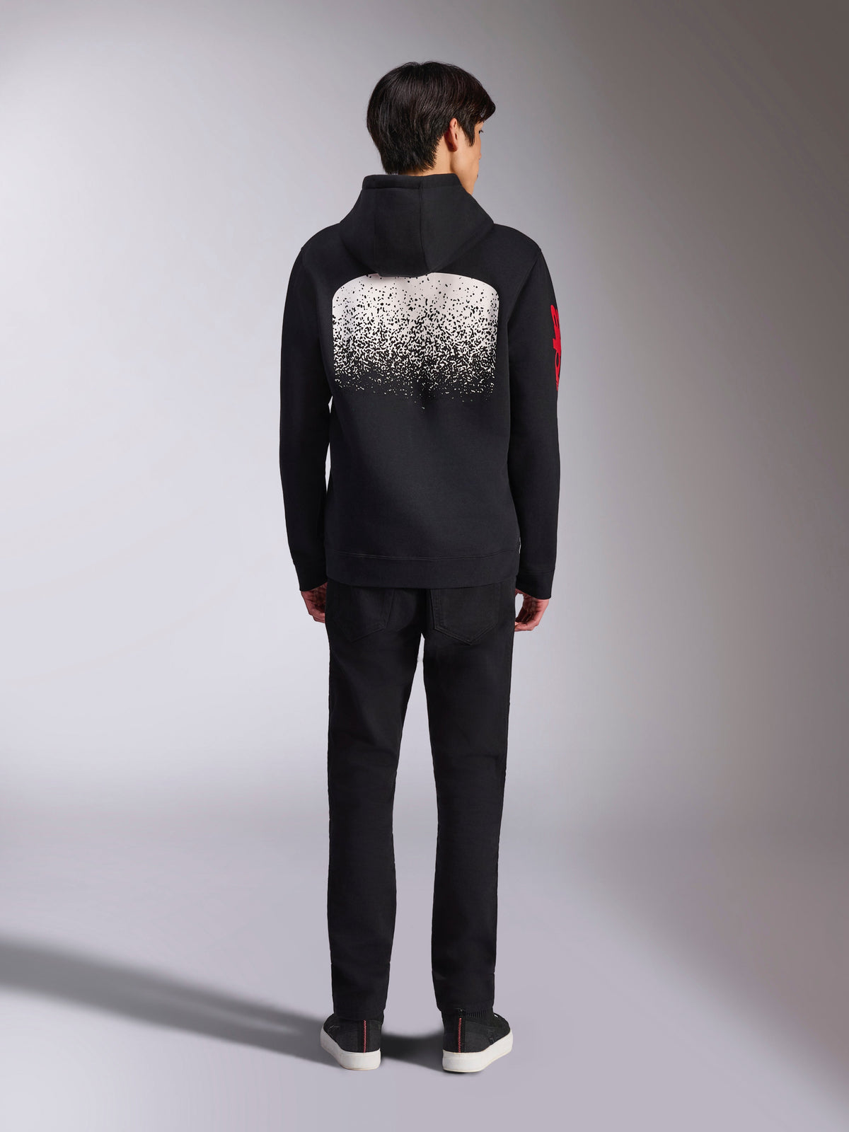 Alpinestars Obsessed Hoodie, lässiger Kapuzenpullover, Schwarz mit weißer MX-Farbverlauf-Grafik auf der Rückseite, rotes Wort-Logo auf dem Ärmel, Rückansicht, getragen mit schwarzer Hose