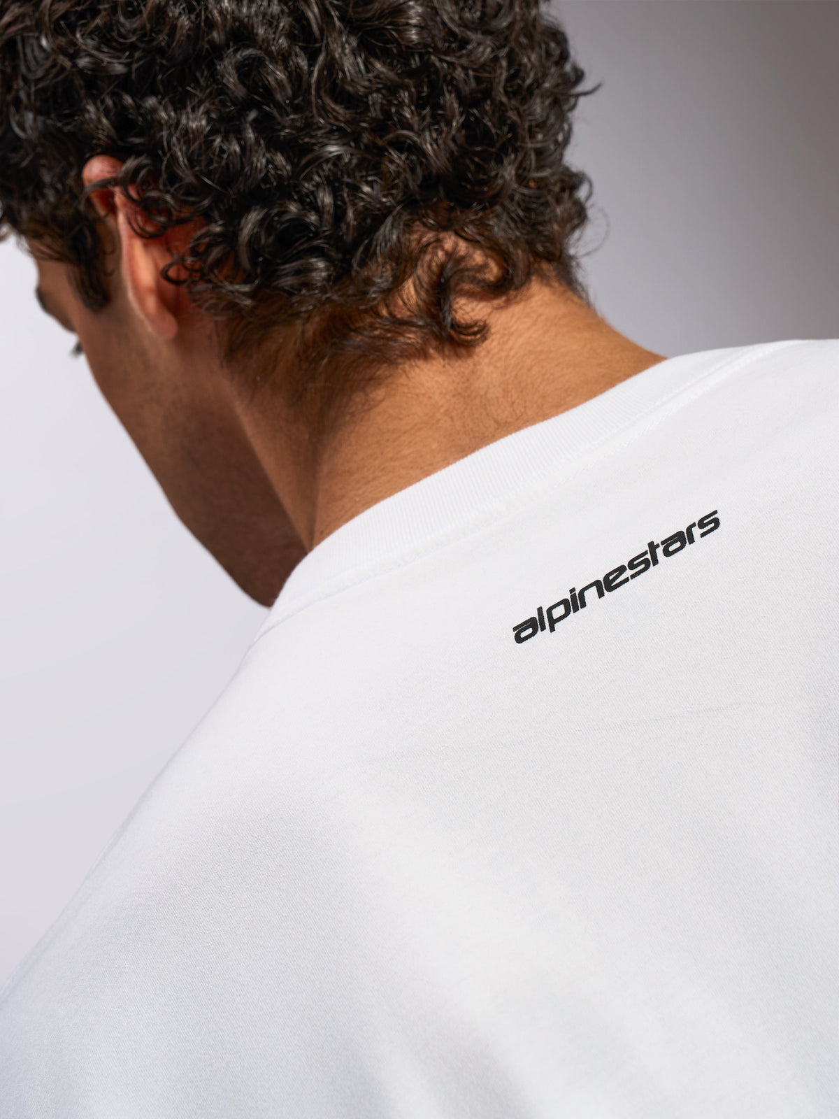 Alpinestars Focused Oversized CSF Tee, Kurzarm-T-Shirt, Weiß, Nahaufnahme des hinteren Nackenbereichs mit kleinem schwarzen Alpinestars Wortlogo, lässiges, vom Motorsport inspiriertes Design