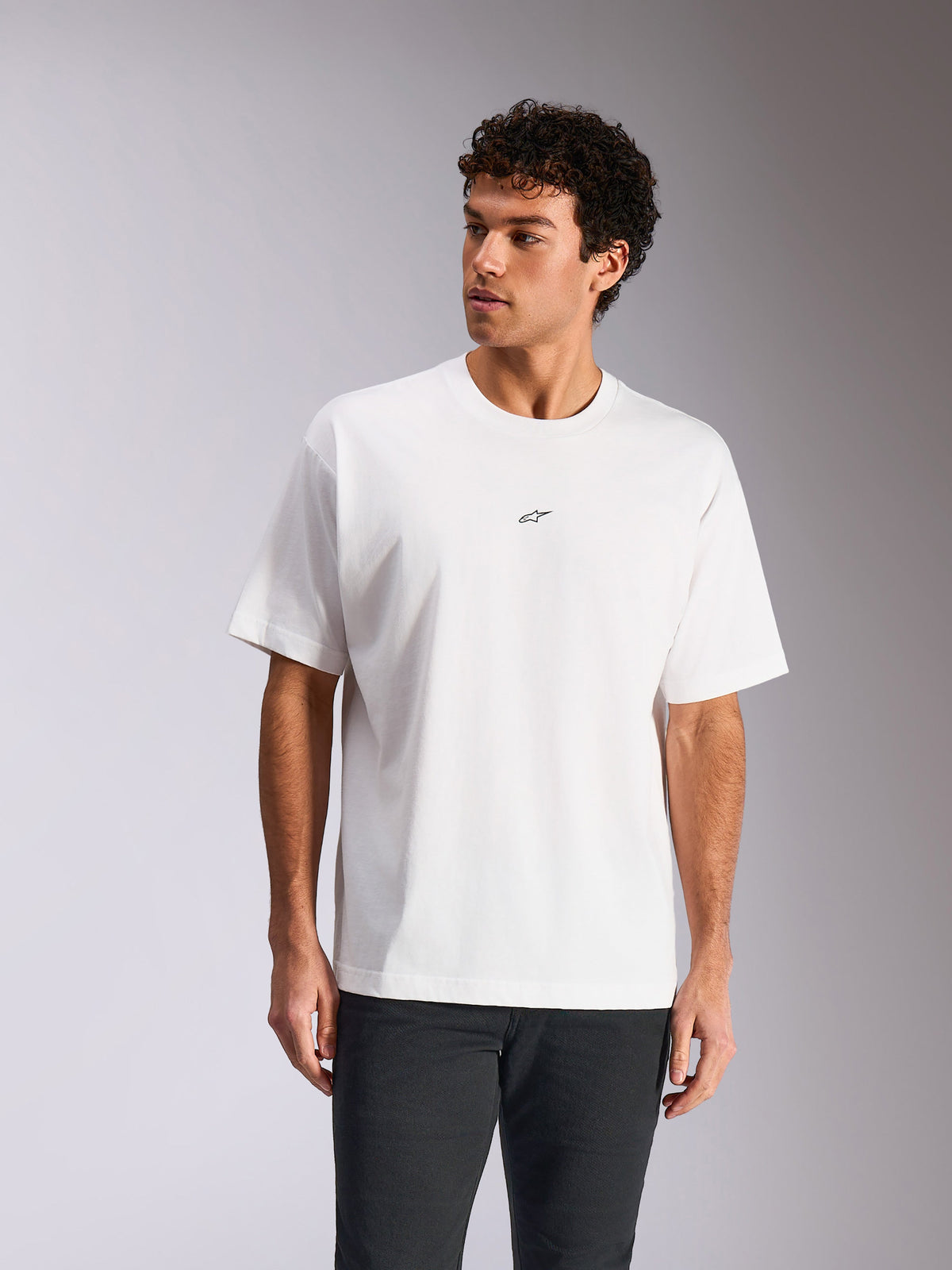 Alpinestars Focused Oversized CSF Tee, kurzärmeliges T-Shirt, Weiß, kleines schwarzes Astars-Logo auf der Brust, lockere Passform getragen von Modell, lässige Motorsport-Streetwear