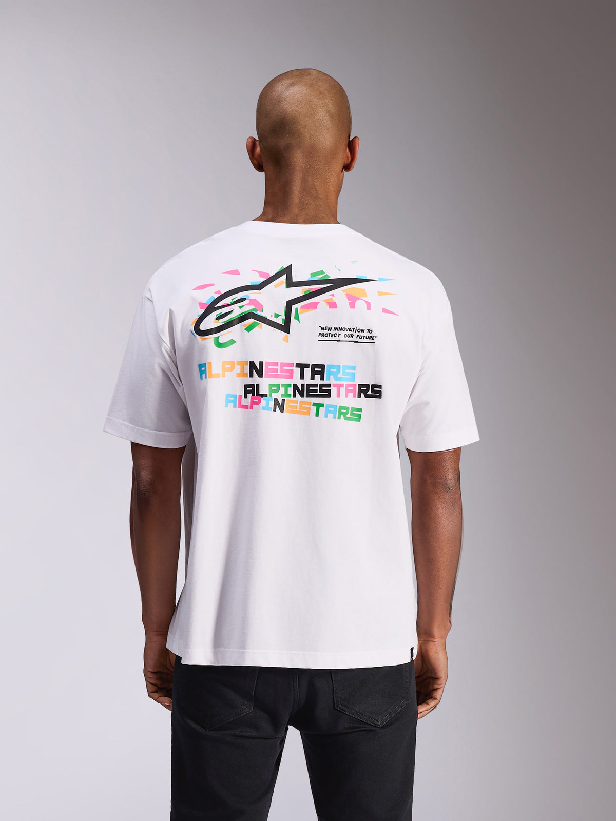 Alpinestars Wild Oversized CSF Tee, Kurzarm-T-Shirt, Weiß, Rückansicht mit lebendigem mehrfarbigem Astars-Logo und Textdrucken, Oversized-Passform, lässige Motorsport-Streetwear