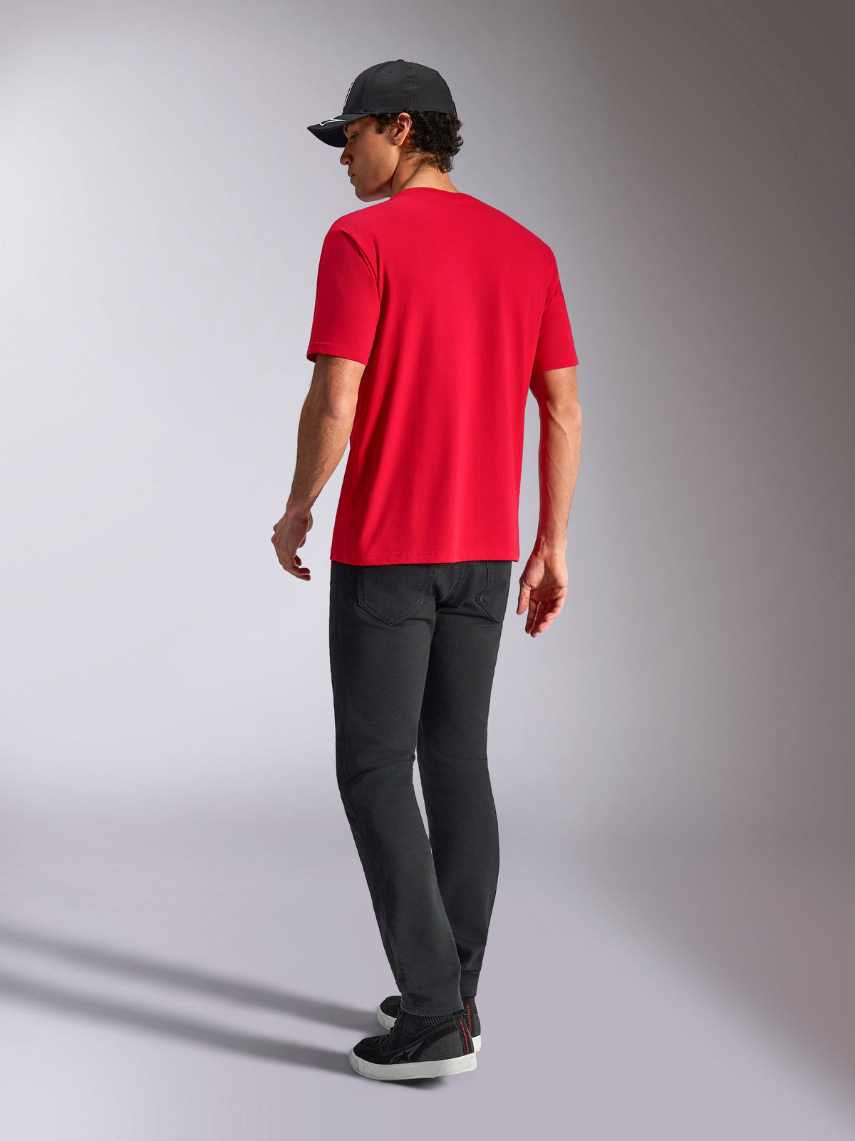 Alpinestars Noka CSF Tee, Kurzarm-T-Shirt, Rot, Rückansicht, kombiniert mit schwarzer Hose und schwarzer Baseballcap, lässige vom Motorsport inspirierte Streetwear