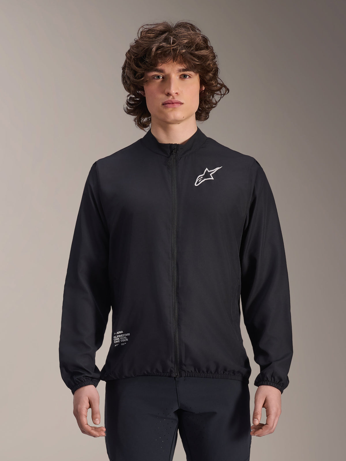 Alpinestars A-Aria Windbreaker-Jacke, Schwarz, leichte Radsportjacke, mit weißem Astars-Logo auf der Brust und Branding unten rechts, durchgehender Reißverschluss vorne, Stehkragen, elastische Bündchen und Saum, Performance-Passform für Outdoor-Sport