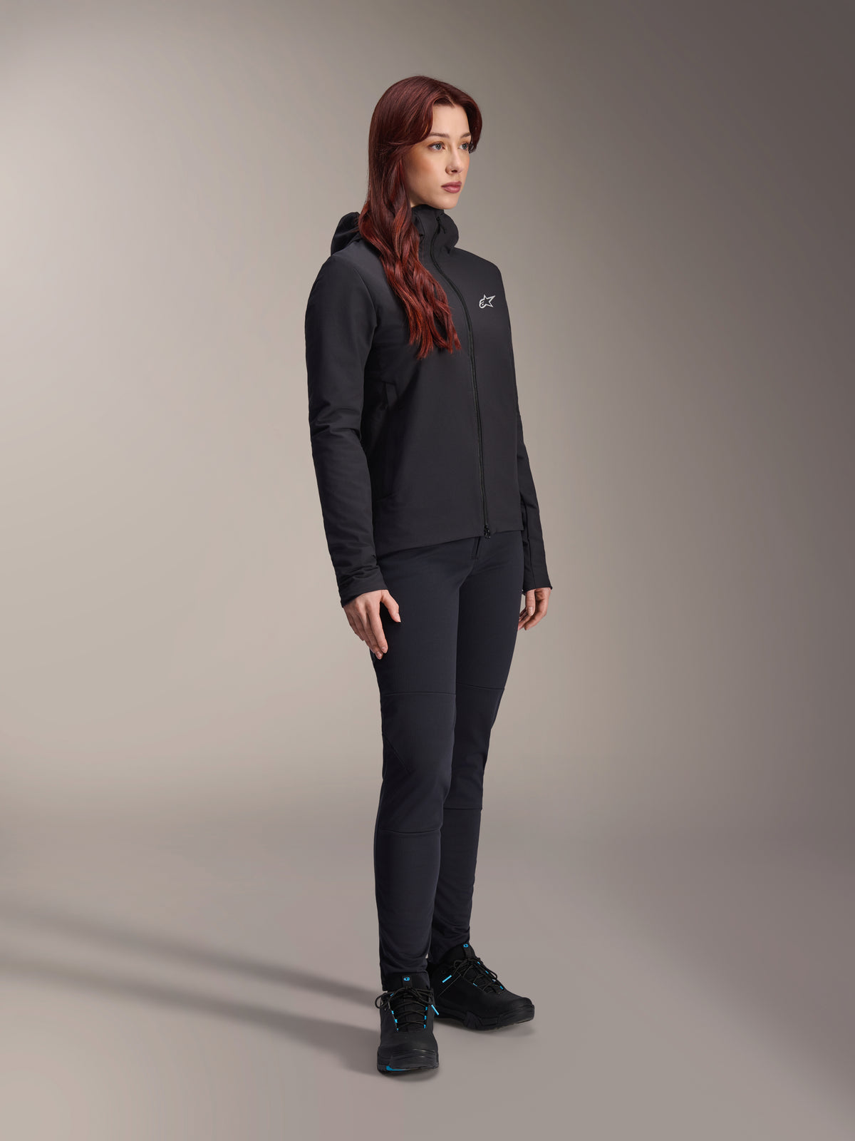 Alpinestars Stella A-Dura Thermal Jacket, woman's black lightweight insulated jacket with hood, worn with black pants and black shoes, professional cycling and mountain bike outfit for cold conditions