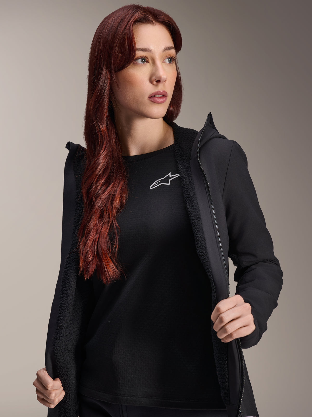 Alpinestars Stella A-Dura Thermal Jacket, Women's Black Cycling Jacket, shown open with textured fleece lining and zippered front, worn over a black t-shirt with the Alpinestars logo, lightweight and insulated for cold-weather riding