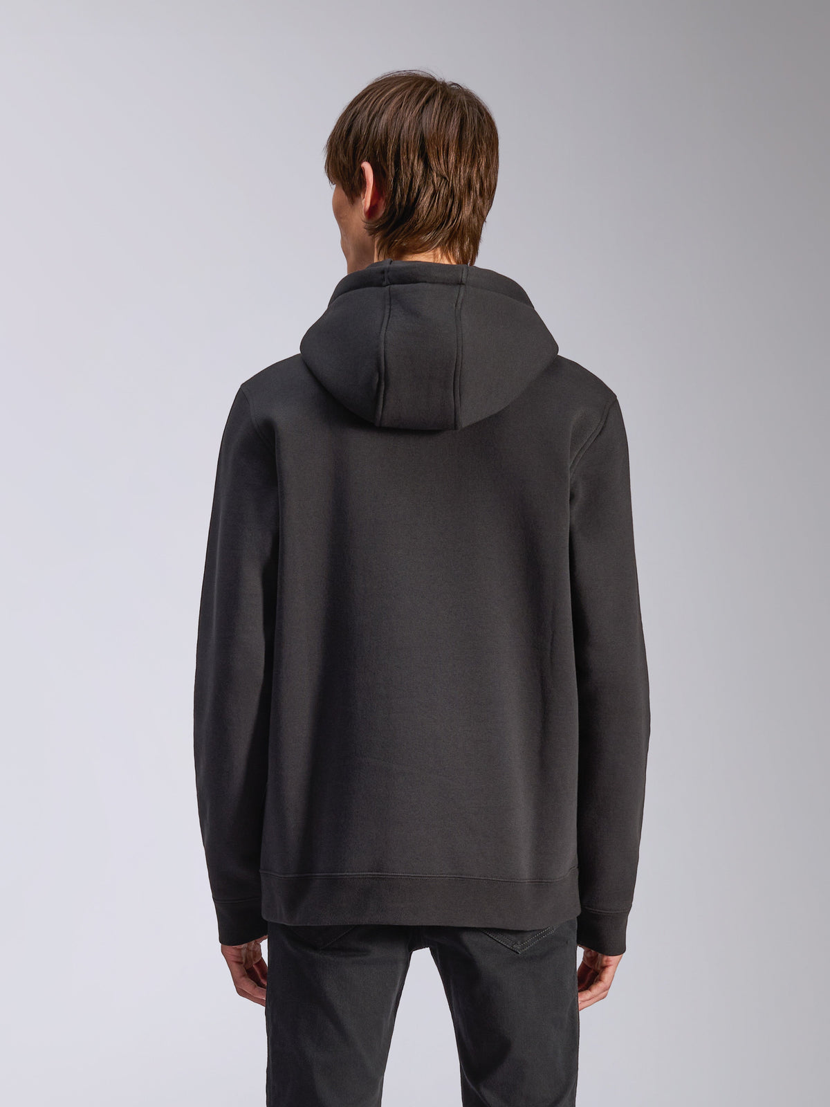 Alpinestars Harken Hoodie, Schwarz, Rückansicht eines männlichen Modells in einem lässigen Fleece-Pullover, Rippbündchen und Saum, moderne motorsport-inspirierte Streetwear