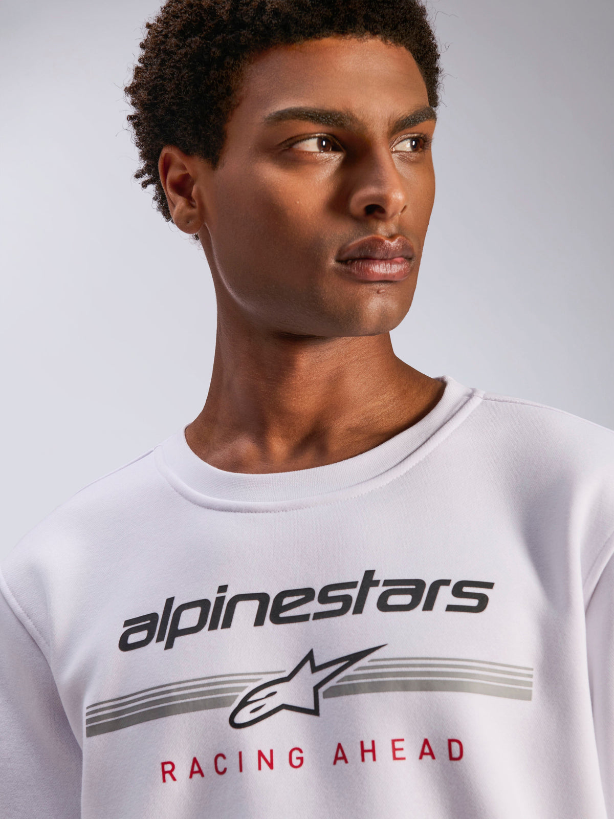Alpinestars Bettern Crew, White Fleece Crewneck, Black Alpinestars logo with grey horizontal lines and red 'Racing Ahead' text, casual motorsport-inspired streetwear
