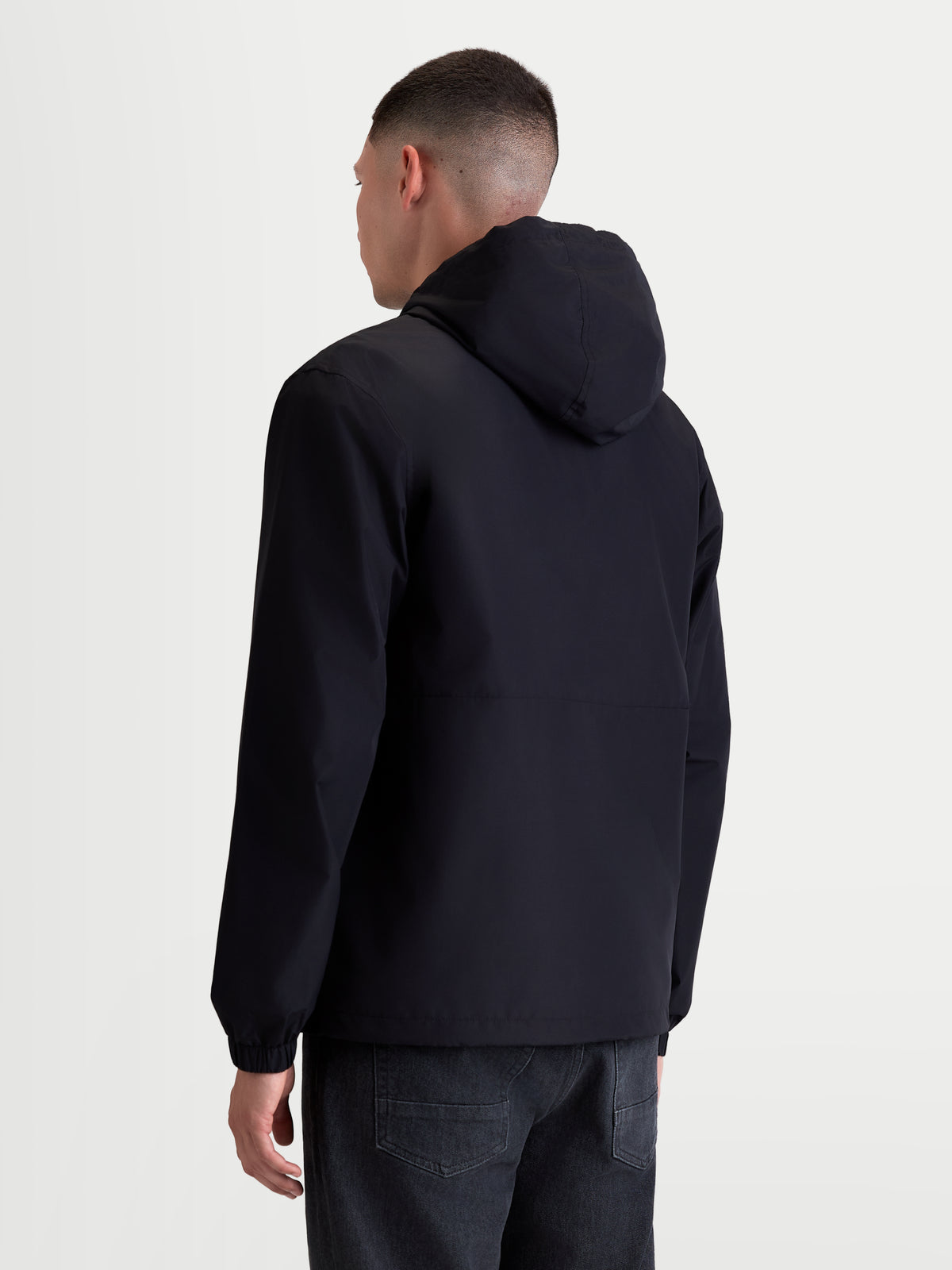 Alpinestars Speeder Resolve Winddichte Jacke, Herren-Sportswear-Jacke für den urbanen Einsatz, Schwarz, Rückansicht am Modell, leichte und atmungsaktive Konstruktion mit verstellbarer Kapuze.