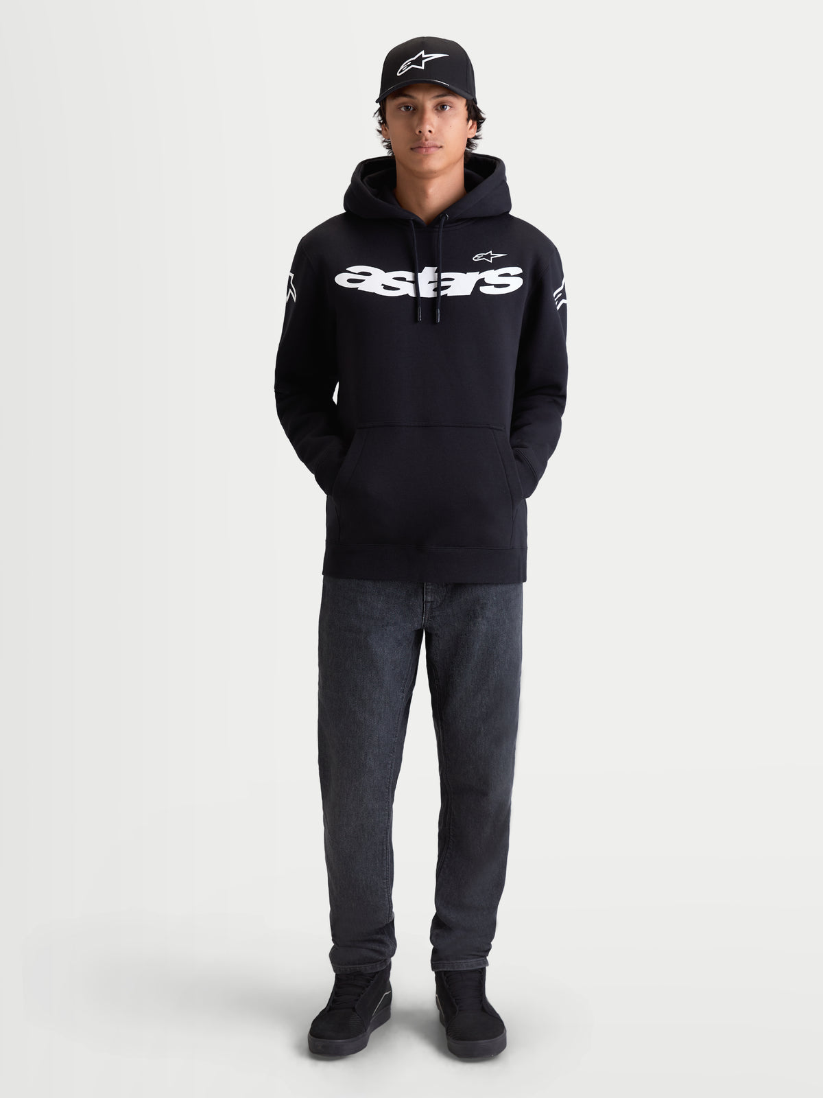 Alpinestars Velocifier Hoodie, Herren-Fleecepullover für die Freizeit, Schwarz und Weiß, Premium-Baumwollmischung, weißer Astars-Schriftzug auf der Brust und Logos an den Schultern, am Modell gezeigt mit passender Kappe.