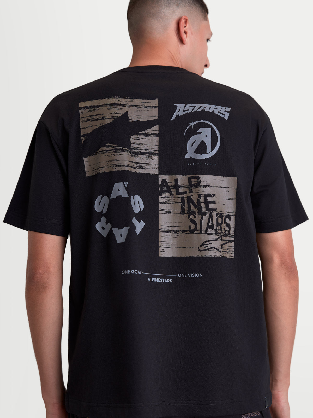 Alpinestars Checkback Oversized CSF T-Shirt, Sportswear T-Shirt in Schwarz mit großer grauer Grafik auf dem Rücken, Astars-Logos, Alpinestars-Schriftzug und One Goal One Vision Slogan, Oversized-Passform, Baumwoll-Polyester-Mischung, Rückansicht am Model.