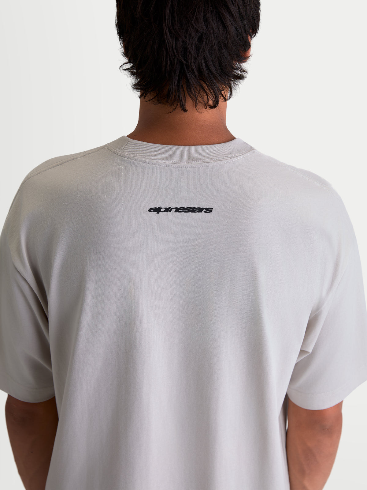 Alpinestars Mandate Oversized CSF T-Shirt, Casual Sportswear Kurzarm-T-Shirt in Grau, mit schwarzem Alpinestars-Wortmarken-Logo auf dem oberen Rücken, Oversized-Passform am Modell.