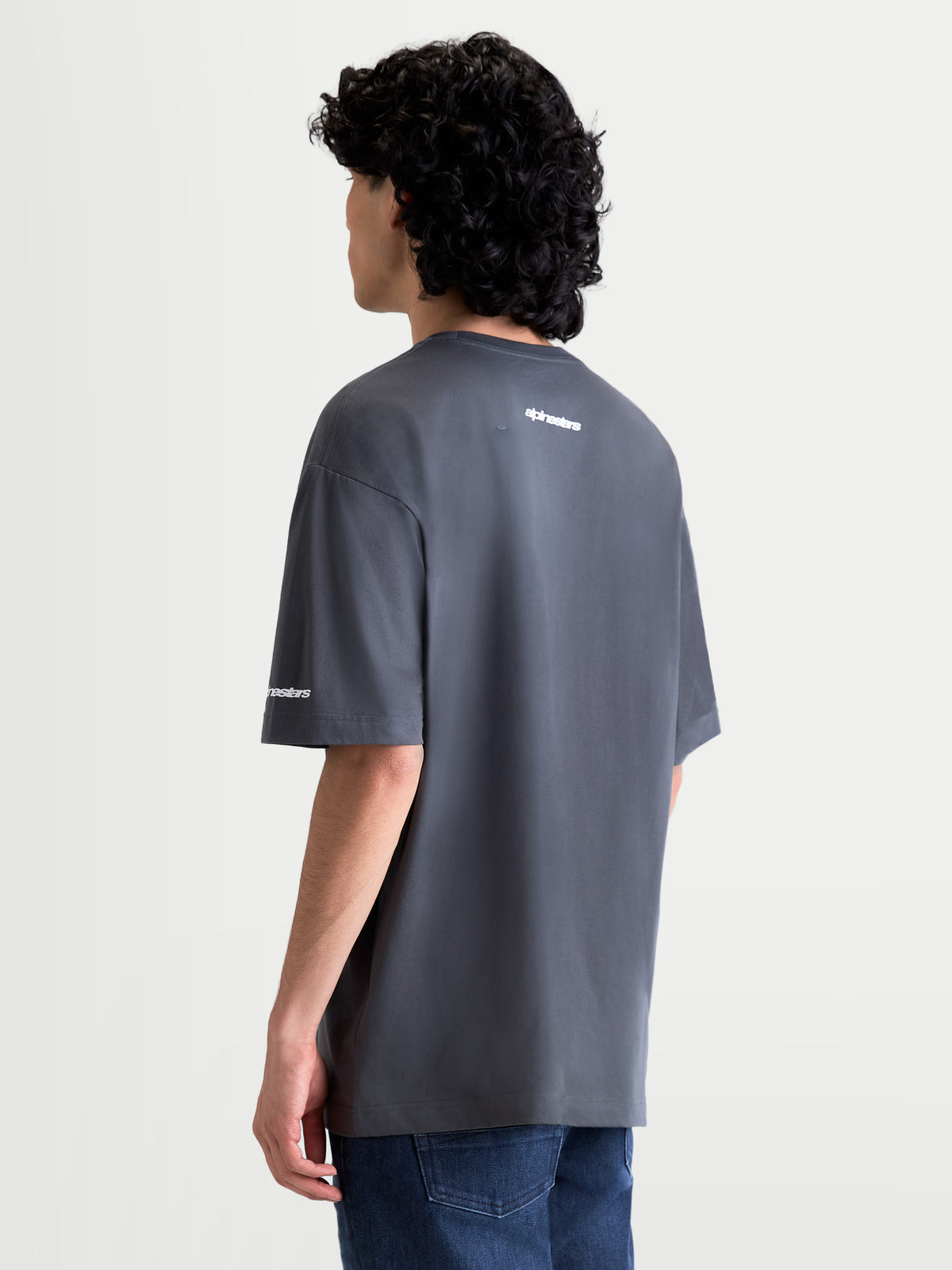 Alpinestars Mandate Oversized CSF T-Shirt, Kurzarm-Sportswear-T-Shirt, Grau, weißes Puff-Druck-Logo auf dem Rücken und am Ärmel, Oversized-Passform, Baumwoll-Mischgewebe, Rückansicht am Modell.