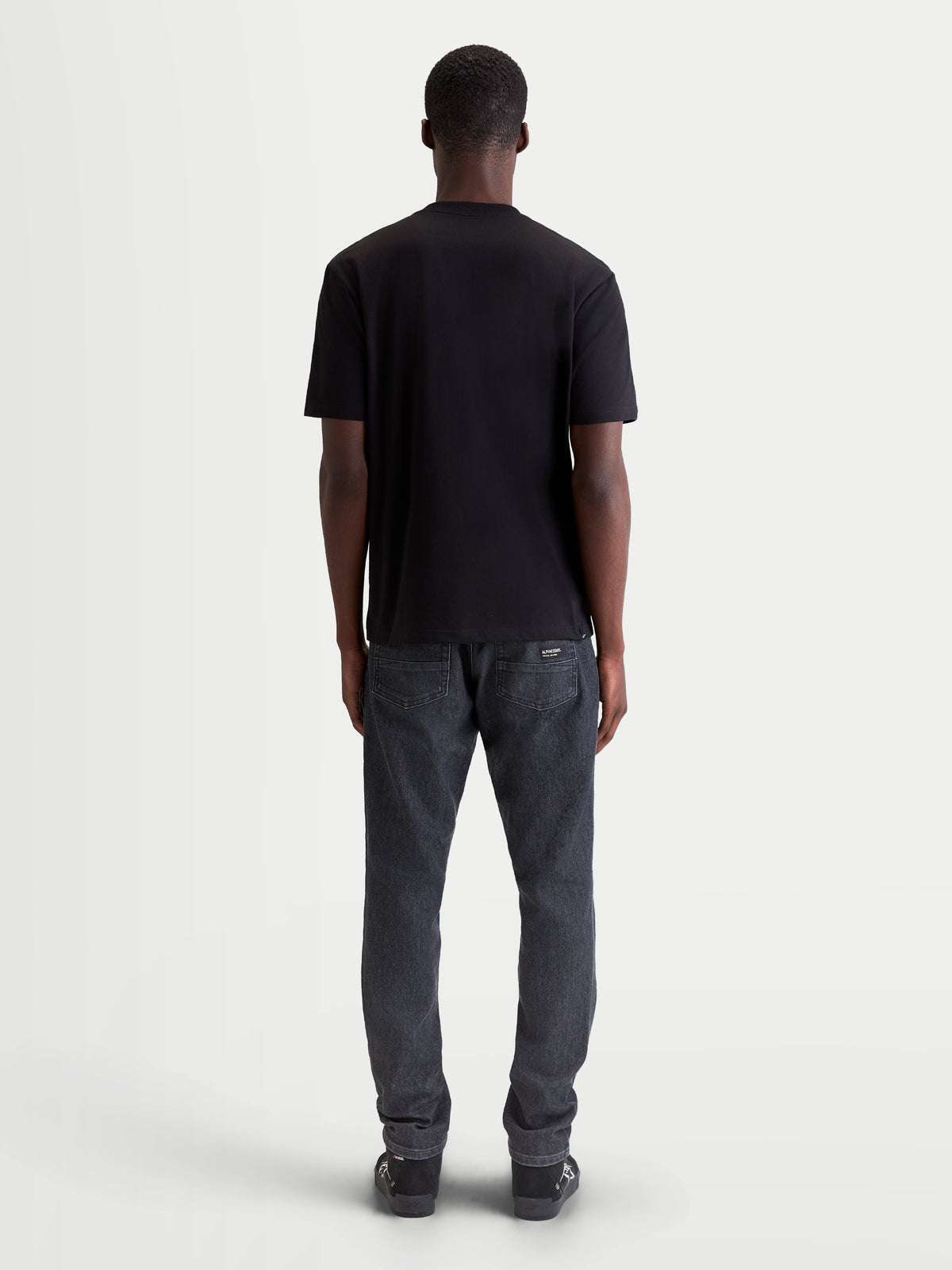 Alpinestars Singular CSF Tee, Short Sleeve Sportswear T-shirt for Men and Women, Black, Back View on Model, Premium Cotton Blend Material for Casual Everyday Wear.
