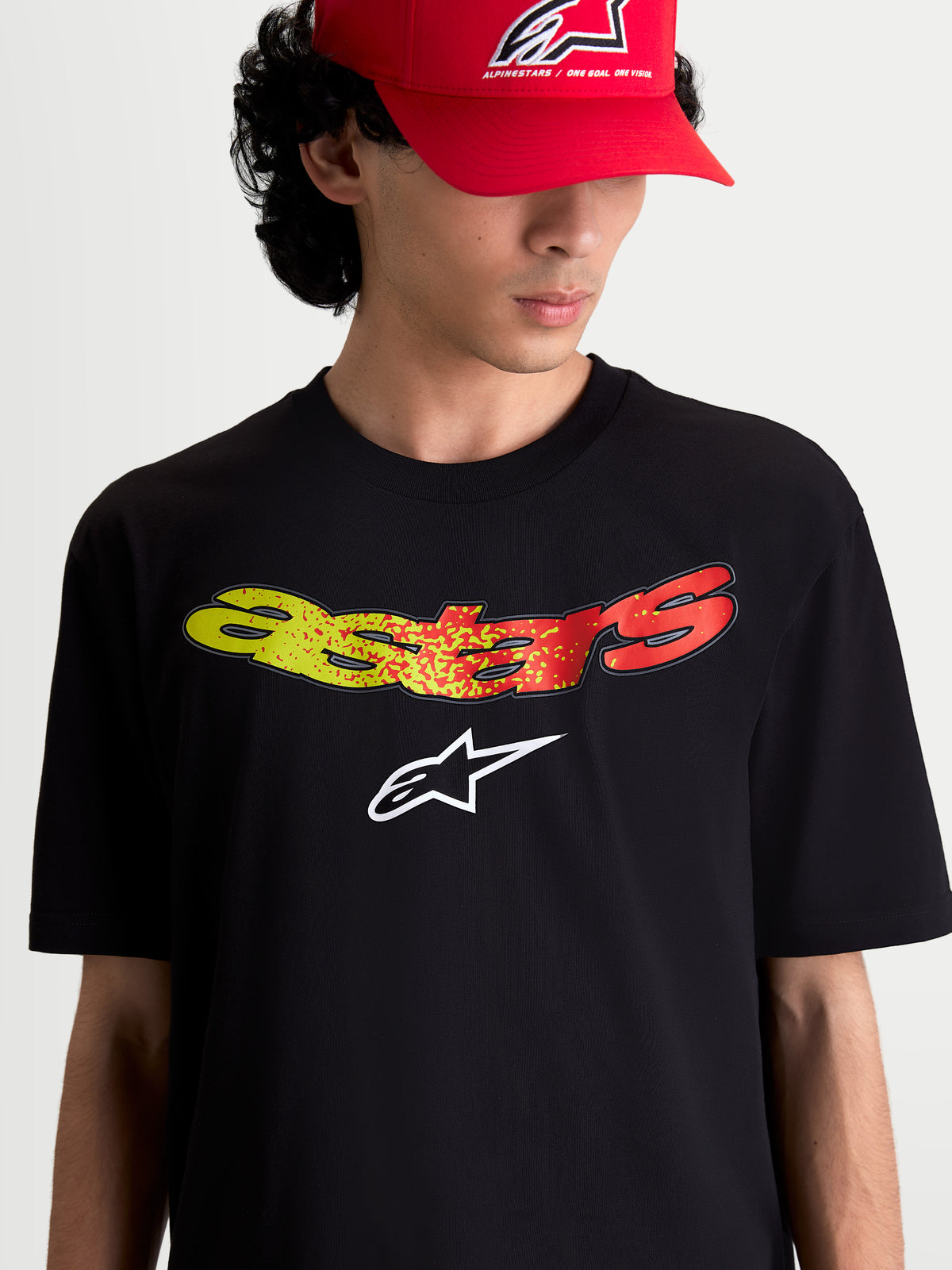 Alpinestars Elliptogrit CSF T-Shirt, Herren-Kurzarm-T-Shirt, Schwarz, mit gelbem und rotem Astars-Schriftzug-Farbverlauf auf der Brust, weicher Frontprint, Sportswear für den Alltag, Baumwoll-Polyester-Mischgewebe.
