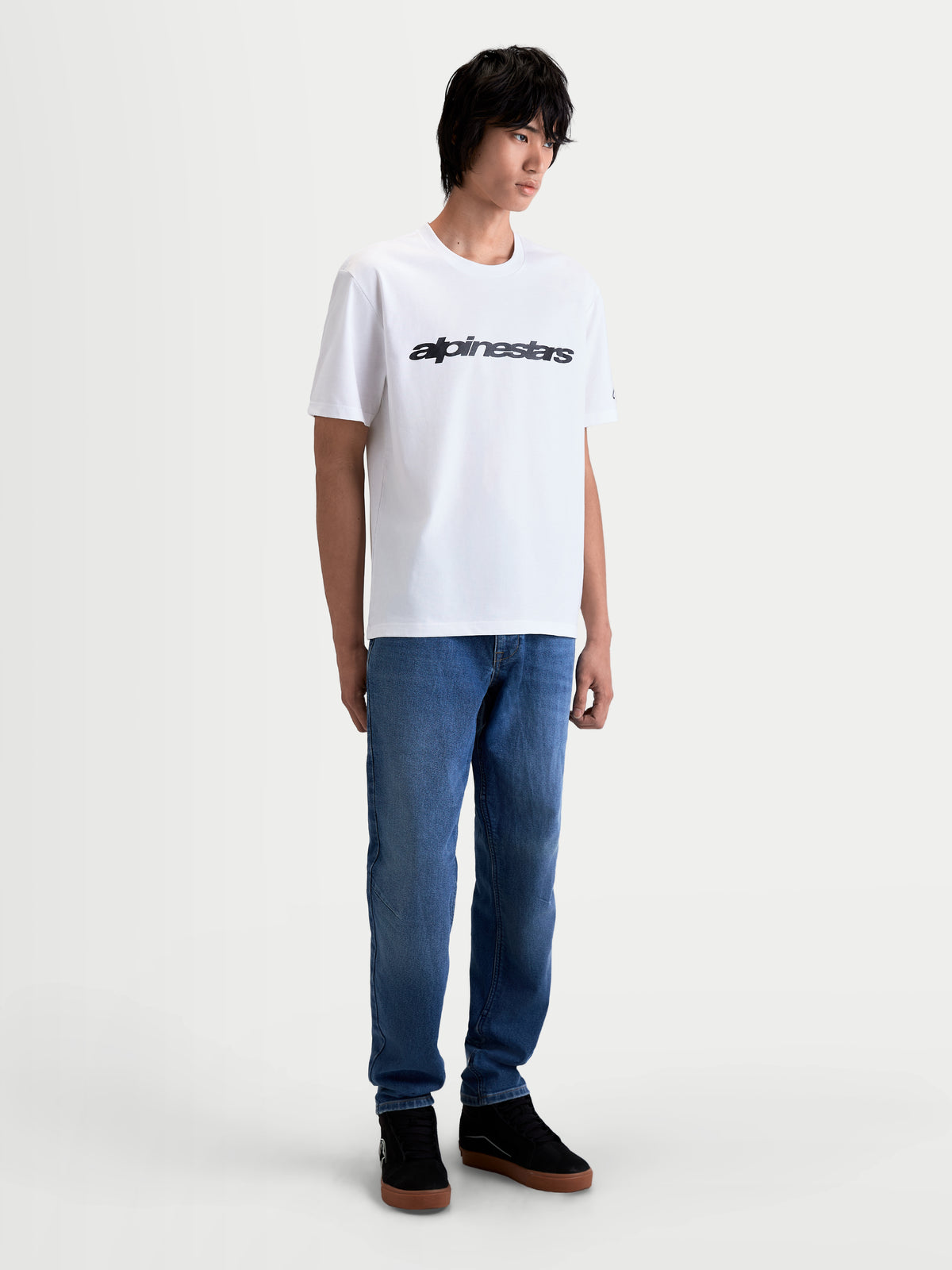 Alpinestars Race Wordmark CSF T-Shirt, lässiges Sportswear-Kurzarm-T-Shirt in Weiß und Schwarz, mit markanter Race-Wordmark-Grafik auf der Brust im Motorsport-Stil, Ansicht am Model.
