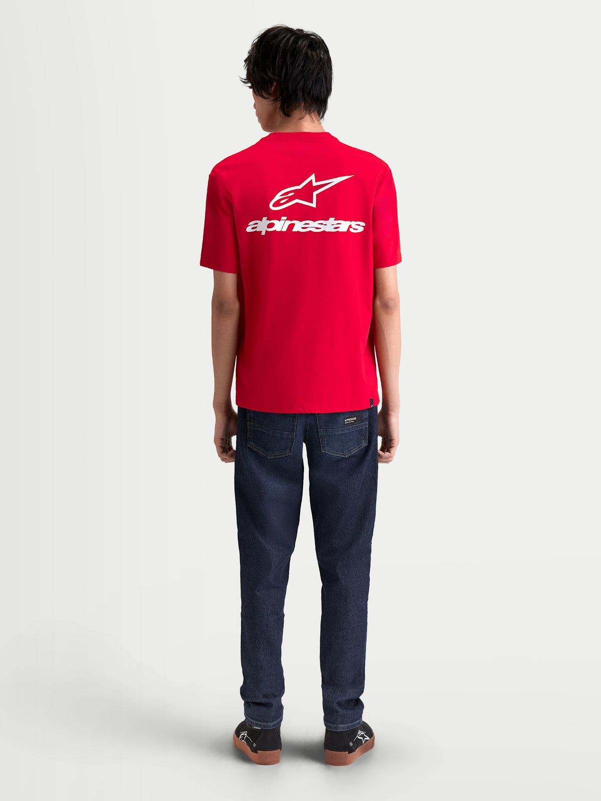 Alpinestars Combo Back CSF T-Shirt, rotes Kurzarm-Sportswear-T-Shirt mit großem weißem Astars-Logo und Wortmarken-Grafik auf dem Rücken, On-Model-Ansicht, hochwertige Baumwoll-Polyester-Mischung für einen lässigen Motorsport-Stil.