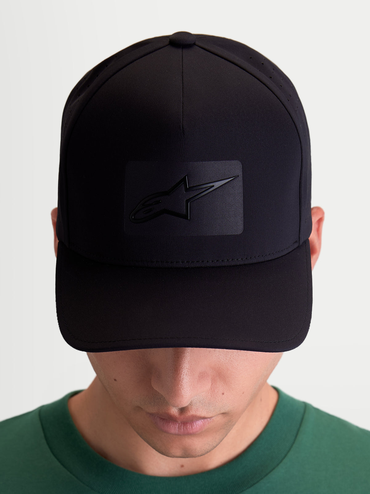 Alpinestars Algo Perf Adjustable Kappe, Sportswear Baseball-Cap für Damen und Herren, schwarzes technisches Funktionsmaterial mit seitlichen Perforationen, gebogener Schirm und strukturierte Krone, Vorderansicht am Modell mit Sonic-Weld Astars-Logo.