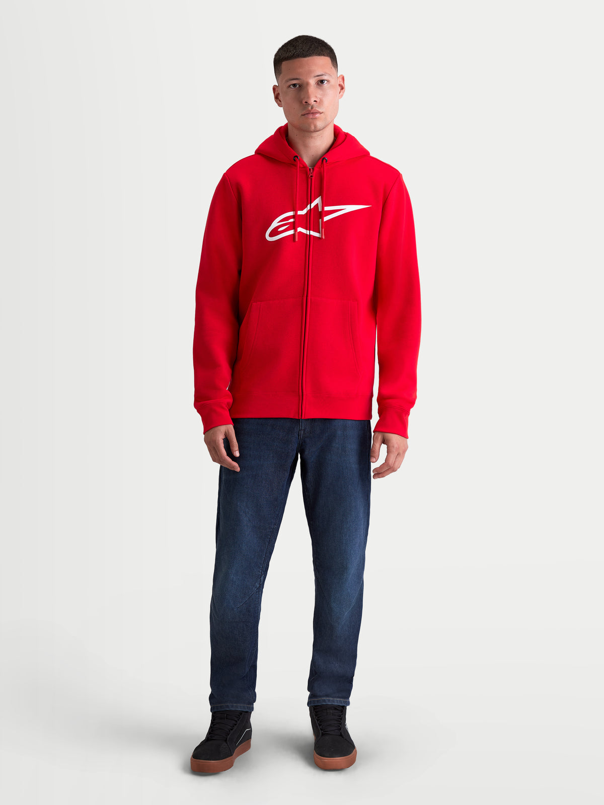 Alpinestars Ageless Zip V3 Hoodie, rote und weiße Sportswear-Kapuzenjacke für Herren, Fleece mit Reißverschluss vorne, markantes weißes Brust-Logo, verdeckter Spiralreißverschluss und Rippbündchen, Frontansicht am Model.