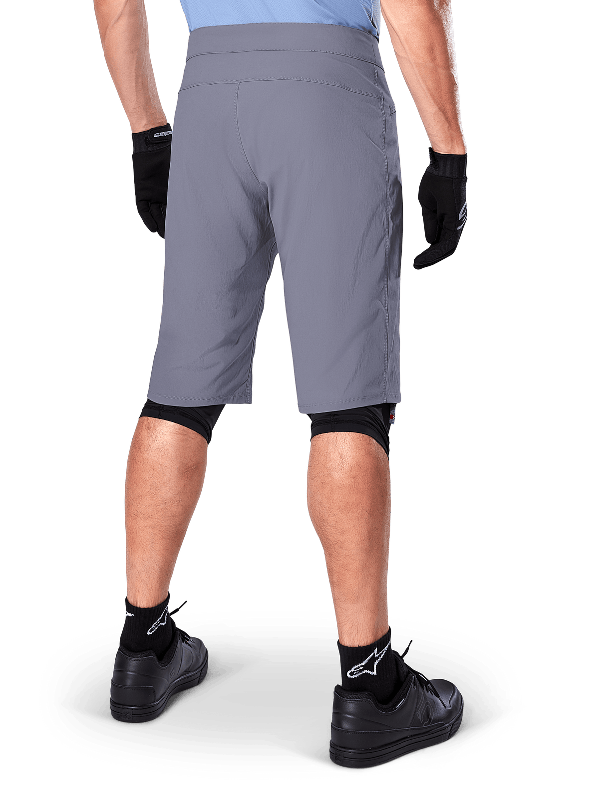 Alpinestars A-Dura Shorts, Dark Gray Mountain Bike Shorts, rear view shown on a rider, worn with black gloves, black knee liners, and black Alpinestars logo socks, durable construction for off-road cycling