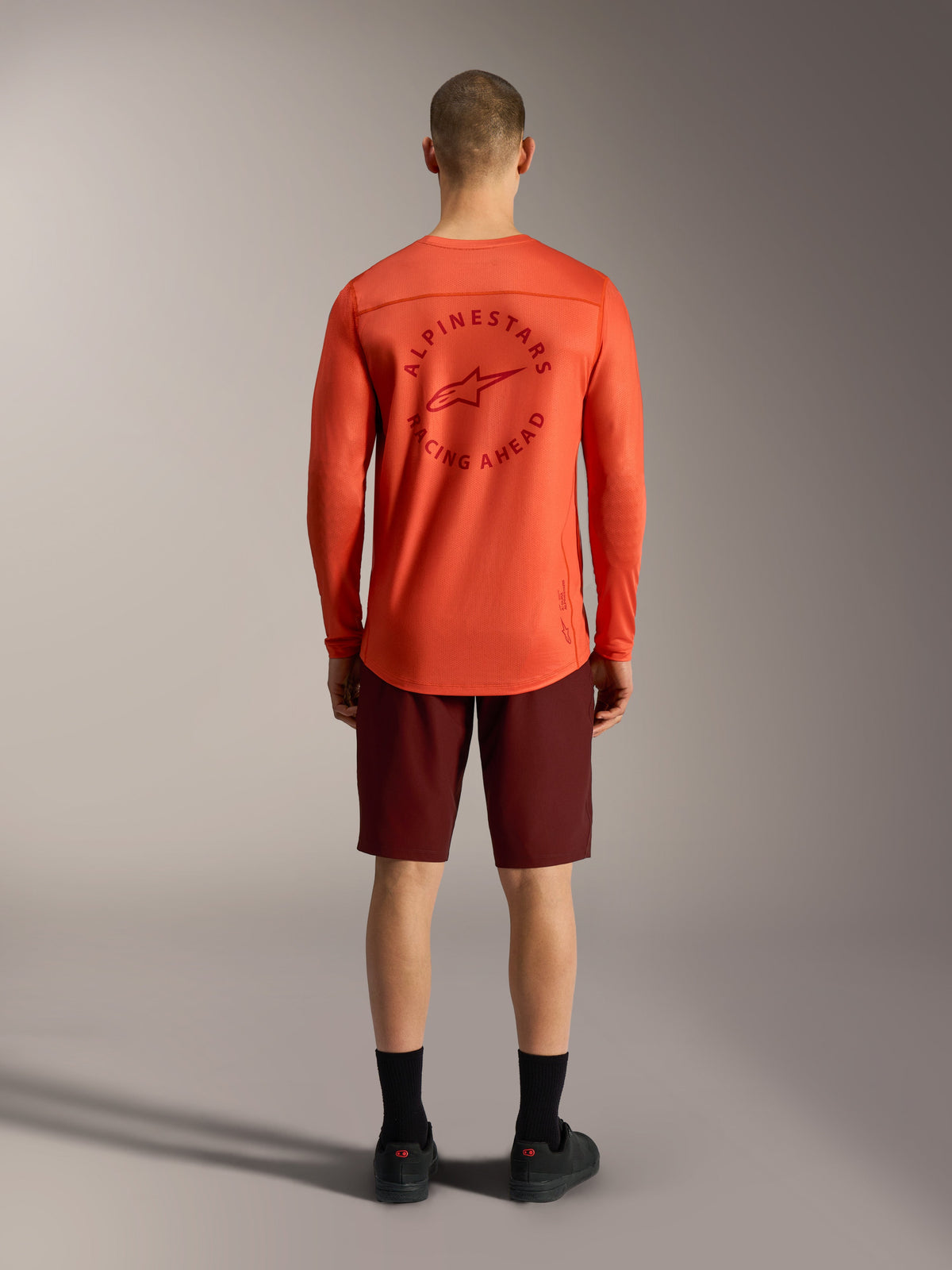 Alpinestars oranges A-Dura Air Langarm-MTB-Trikot und bordeauxrote A-Dura Ride Shorts in der Rückansicht.