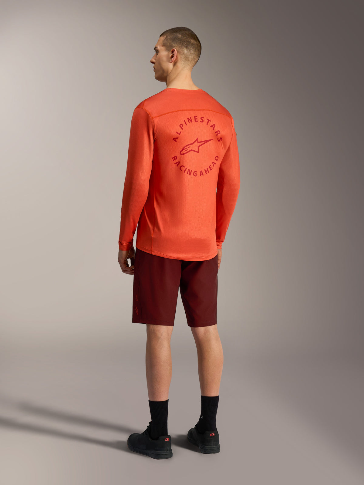 Alpinestars A-Dura Ride Shorts in Bordeaux und oranges A-Dura Air LS Jersey, Rückansicht von MTB-Ausrüstung.