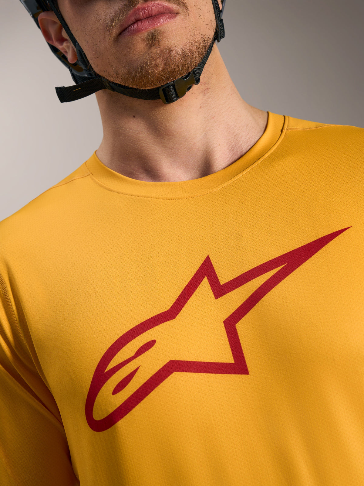 Oranges A-Dura Ride Kurzarmtrikot mit rotem Astars-Logo auf der Brust, leichte MTB-Performance-Bekleidung.