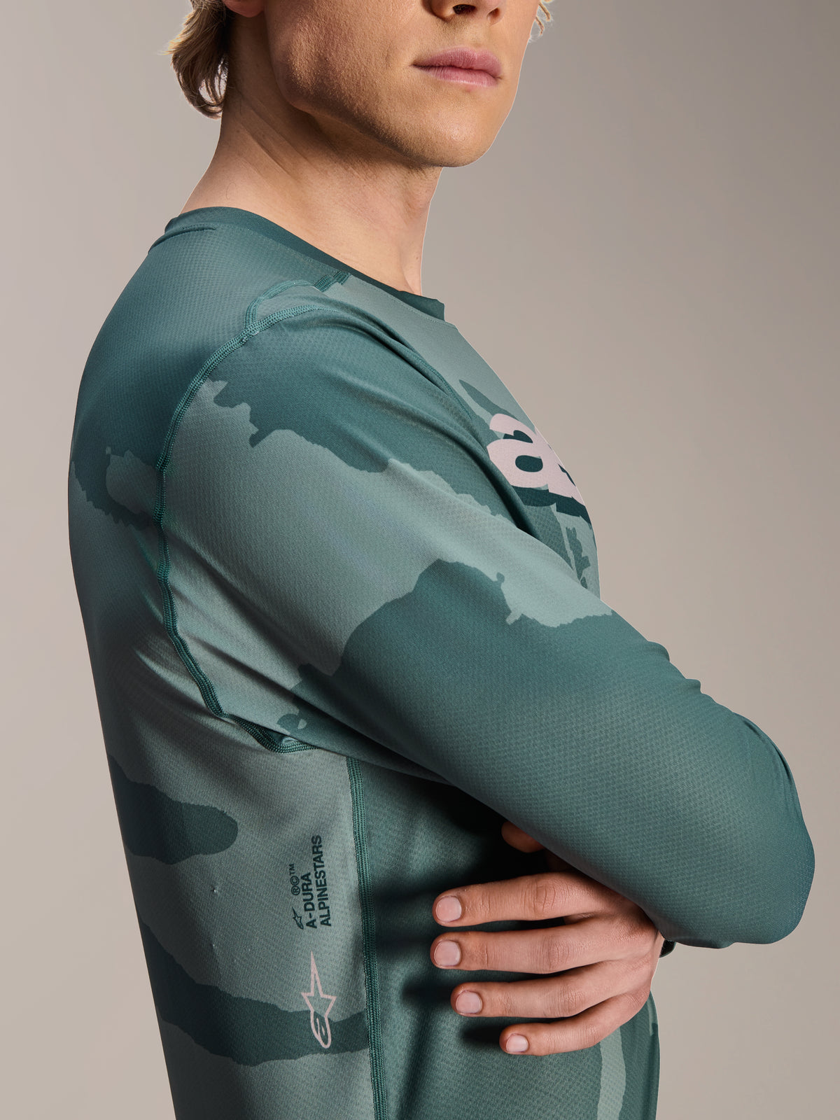 Alpinestars A-Dura Hollow Camo Langarmtrikot, Silver Pine Camo, grünes Camouflage-Muster, mit A-Dura Schriftzug und Astars-Logo auf der Seite, technische MTB-Fahrbekleidung