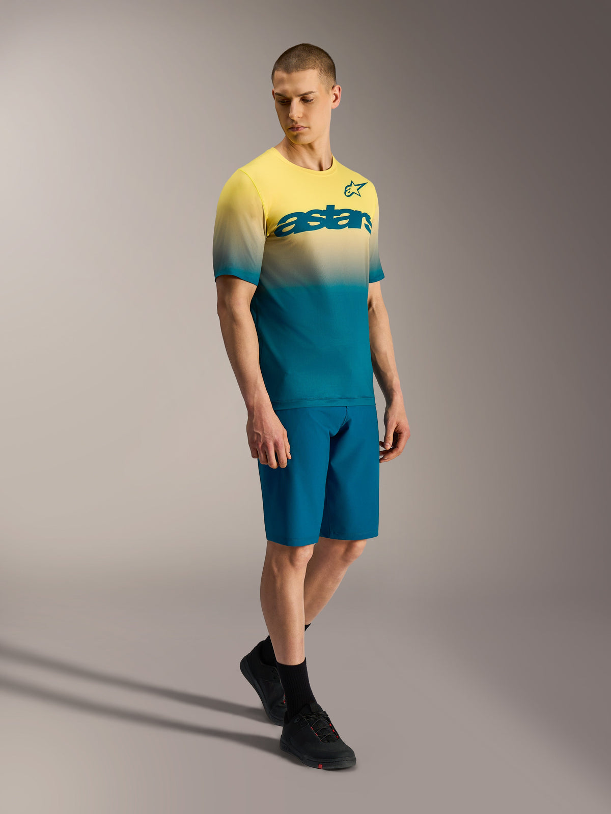 A-Dura ASTARS Jersey 2.0 mit gelb-blauem Farbverlauf, Kurzarm-MTB-Trikot mit Brust-Branding an einem Model.