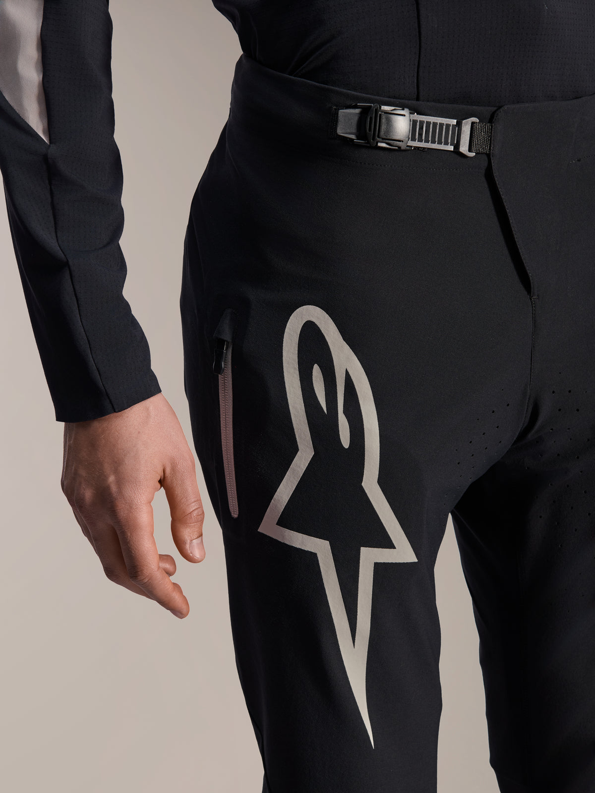 Alpinestars A-Supra Melt Hose, Mountainbike-Hose, Schwarz, mit großem weißen Astar-Logo auf dem Oberschenkel, verstellbarem Ratschenverschluss und seitlicher Reißverschlusstasche, Detailansicht technischer Performance-MTB-Ausrüstung