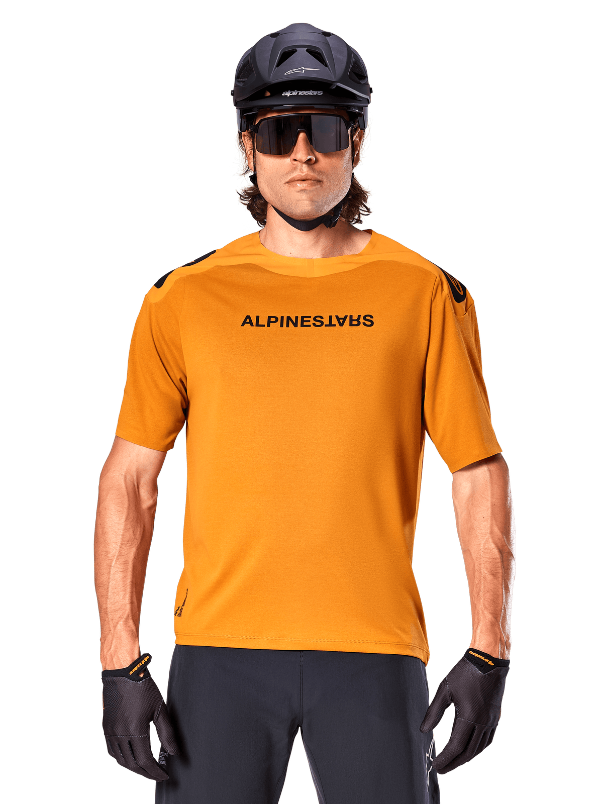 Alpinestars A-Aria Polartec Switch Kurzarm-Trikot, Dunkelgold, Mountainbike-Fahrer mit schwarzem Helm und Sonnenbrille, Performance-Radsportbekleidung für MTB-Trails