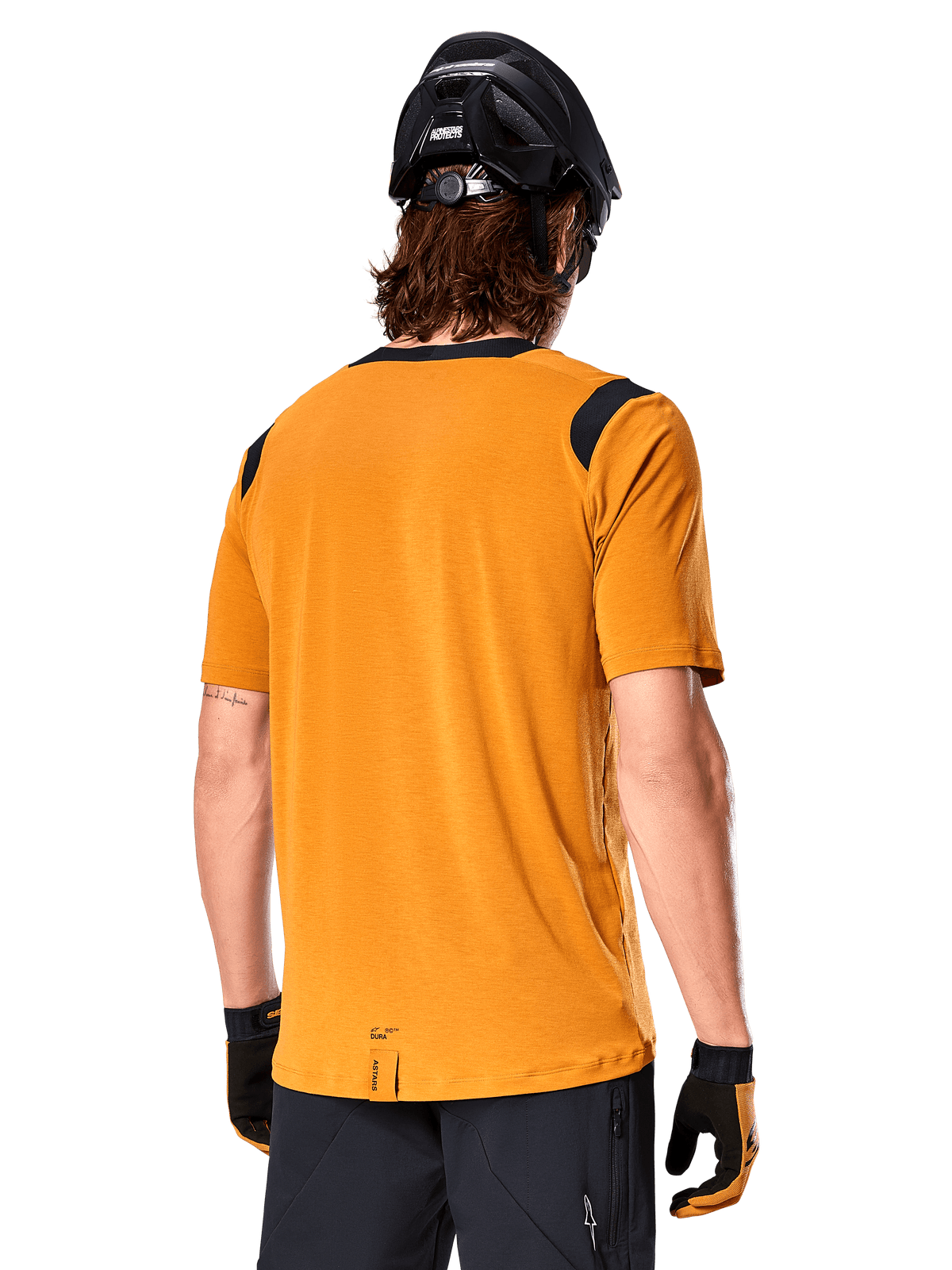 Alpinestars A-Dura Dri Wool Short Sleeve Jersey, Dark Gold, Rear view of a man wearing the short-sleeve jersey with black mesh panels on the shoulders, paired with a black MTB helmet and gloves, regular fit mountain bike gear.