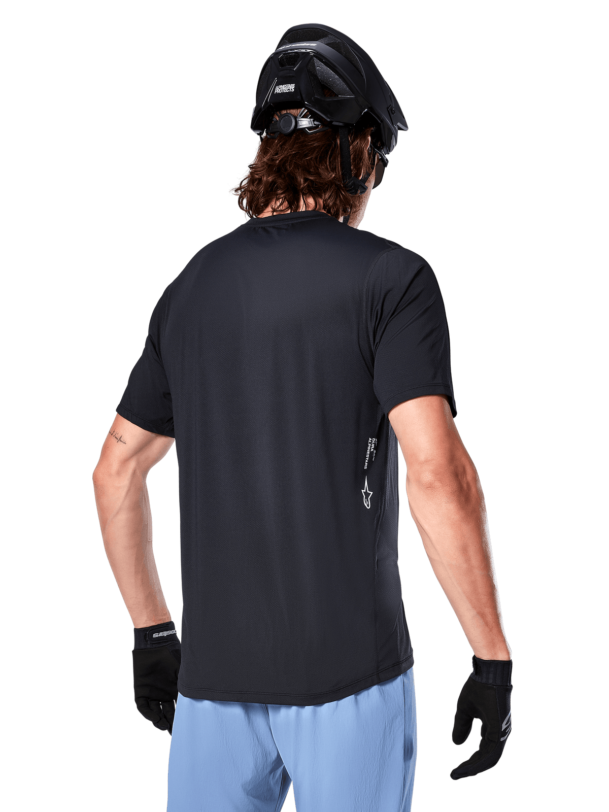 Alpinestars A-Dura Oscar Jersey, Short Sleeve cycling jersey, Black, rear view on rider, paired with light blue shorts and black MTB helmet, small white logo on the side, performance apparel for mountain biking