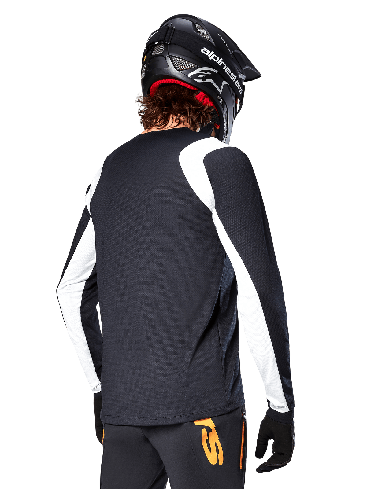 MTB-Fahrer im Alpinestars A-Supra Oscar Langarm-Trikot, Schwarz mit weißen Einsätzen an den Schultern und Ärmeln, Rückansicht, schwarzer Helm und Handschuhe, Hose mit orangefarbenen Akzenten, strapazierfähige Offroad-Radsportbekleidung