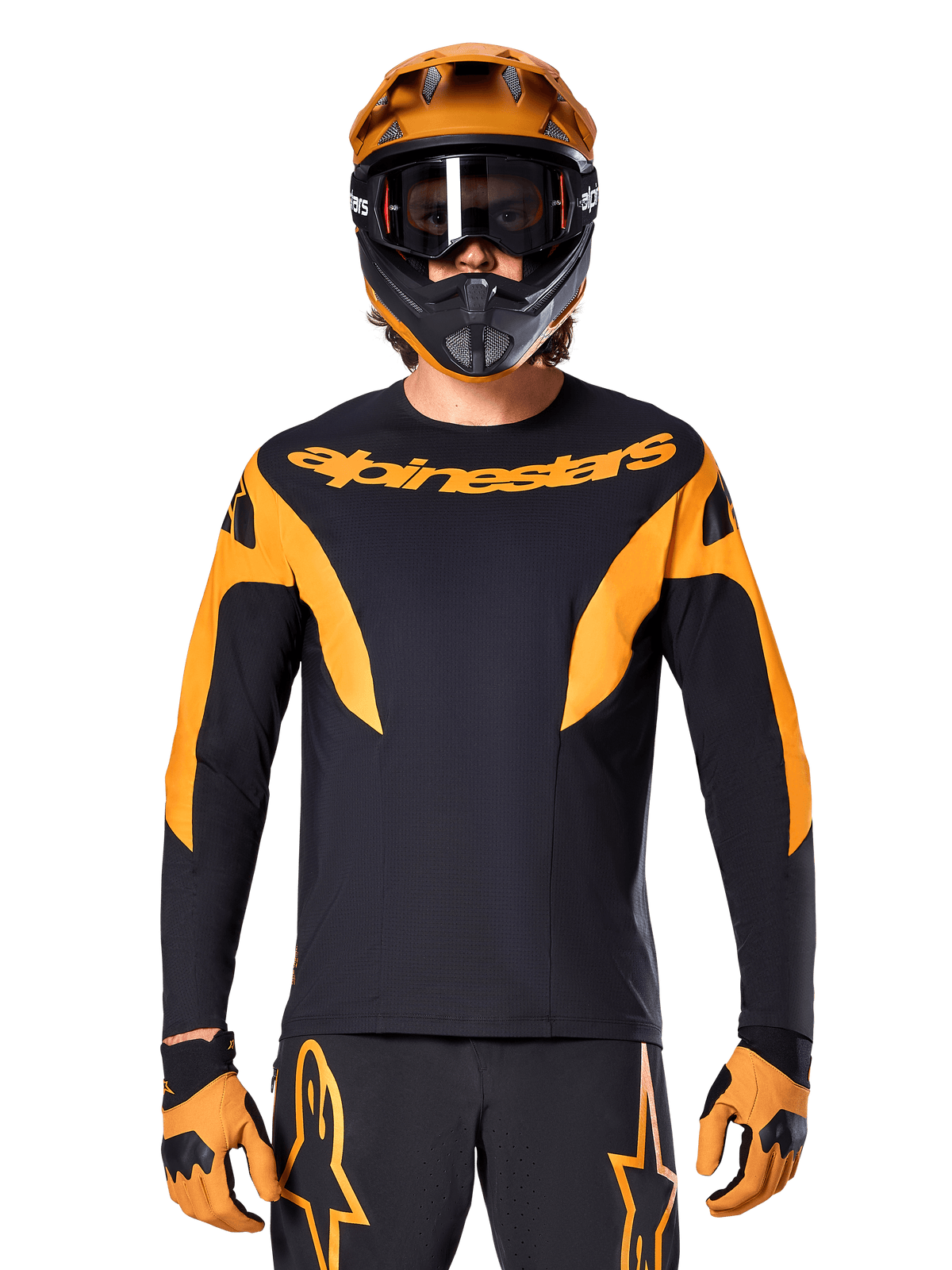MTB-Fahrer trägt Alpinestars A-Supra Race Trikot – Langarm, Schwarz mit orangefarbenen Grafiken und Brustlogo, kombiniert mit passendem orangefarbenem Fullface-Helm, schwarzer Goggle und orangefarbenen Handschuhen, koordinierte Rennausrüstung für Mountainbike-Performance