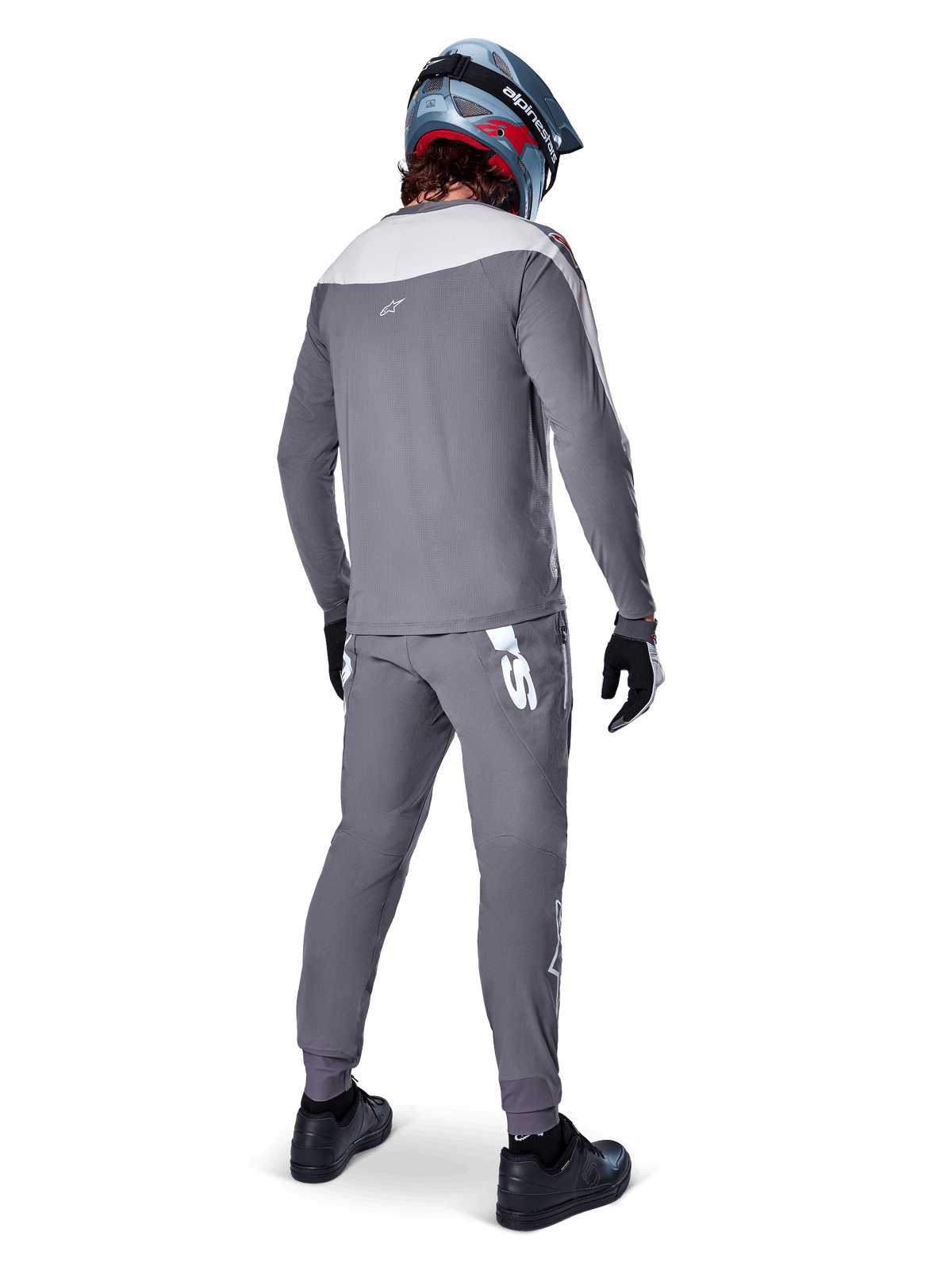 Alpinestars A-Supra Race Trikot, Langarm-MTB-Trikot, Dunkelgrau mit hellgrauem Schultereinsatz, Rückansicht getragen mit passender Hose, blau-roter Fullface-Helm, schwarze Handschuhe und Schuhe, rennsportinspirierte Performance-Radsportausrüstung