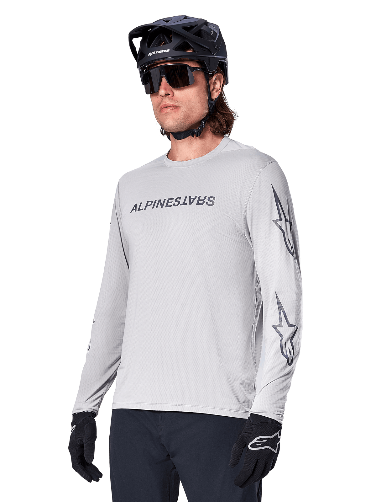 Alpinestars A-Dura Switch Long Sleeve Jersey, Mountain Bike Jersey, Light Gray, black wordmark screen print on chest and star logos on sleeves, worn with black mountain bike helmet, dark sunglasses, and black gloves, athletic off-road cycling gear