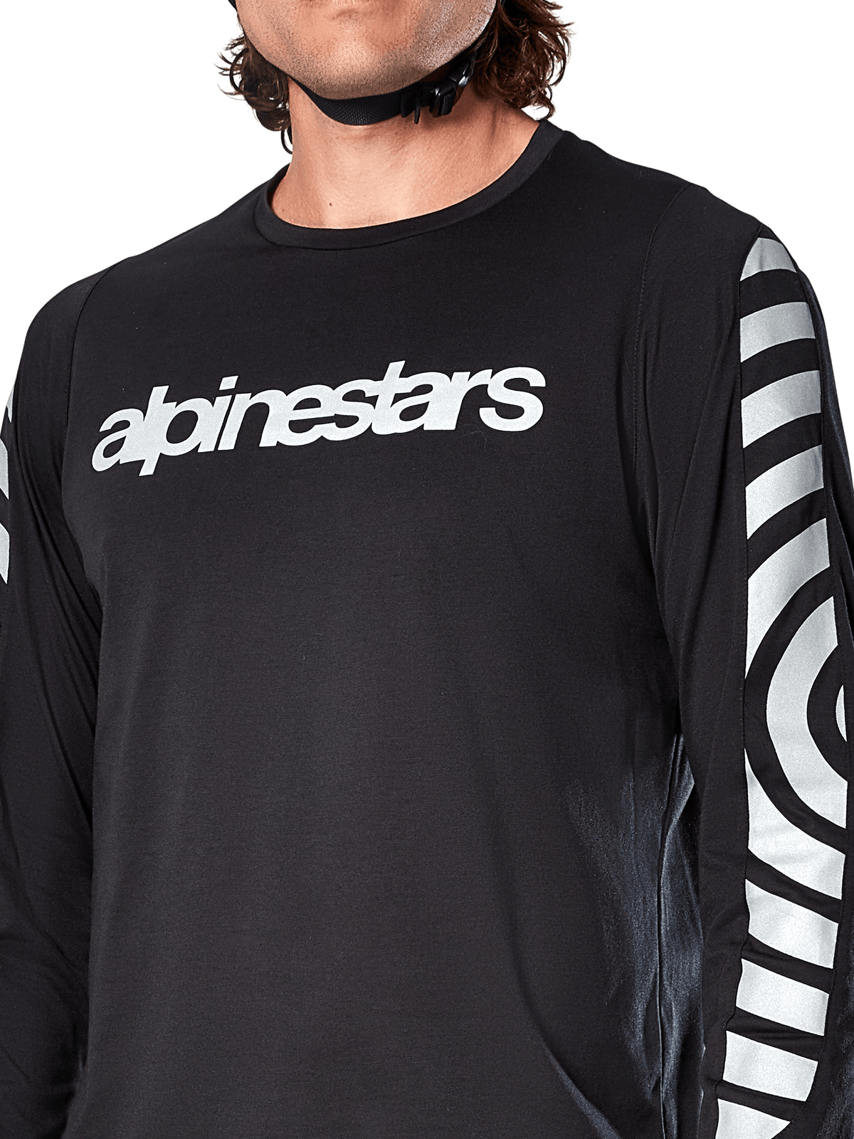 Alpinestars A-Dura Dri Oscar Langarmtrikot, Black Reflective, Nahaufnahme mit weißem Alpinestars-Logo auf der Brust und reflektierenden kreisförmigen Grafiken auf den Ärmeln, technische Radsportbekleidung für Mountainbiking