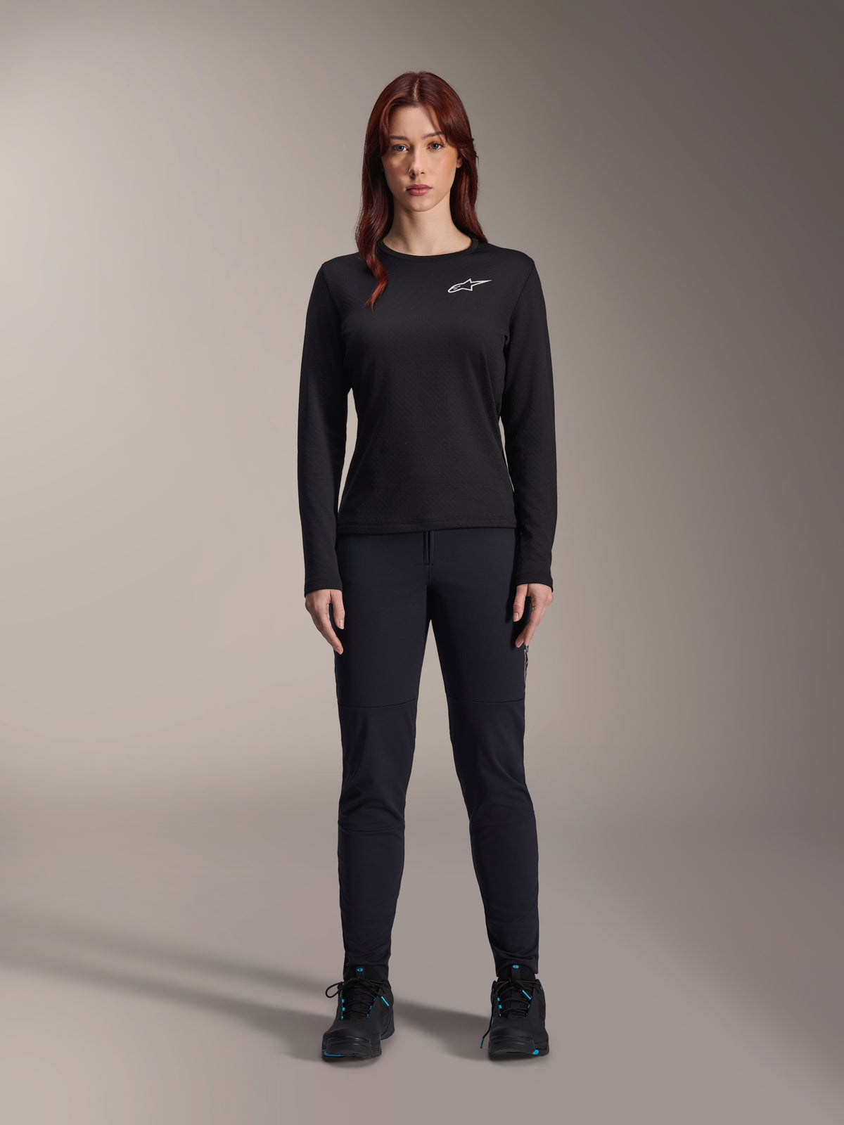 Alpinestars Stella A-Dura Thermal Jersey, Woman's Long-Sleeve Mountain Bike Jersey in Black, featuring a white chest logo, worn with matching black gear and cycling shoes, studio portrait.
