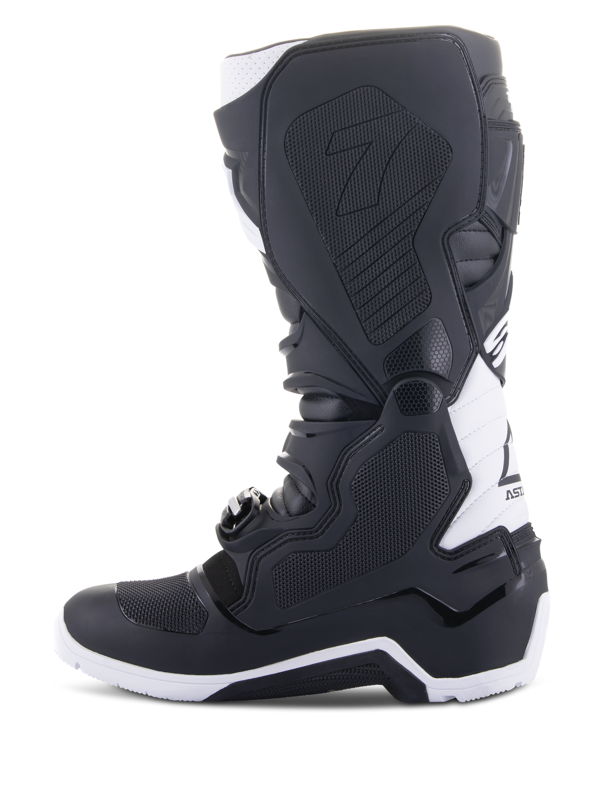Alpinestars Tech 7 Enduro Drystar® Stiefel, Enduro-Motorradstiefel, Schwarz und Weiß, mediale Seitenansicht mit wabenförmig strukturierten Grip-Panels, TPU-Konstruktion und weißen Akzenten an Ferse und oberem Wadenbereich, professionelles Offroad-Schuhwerk