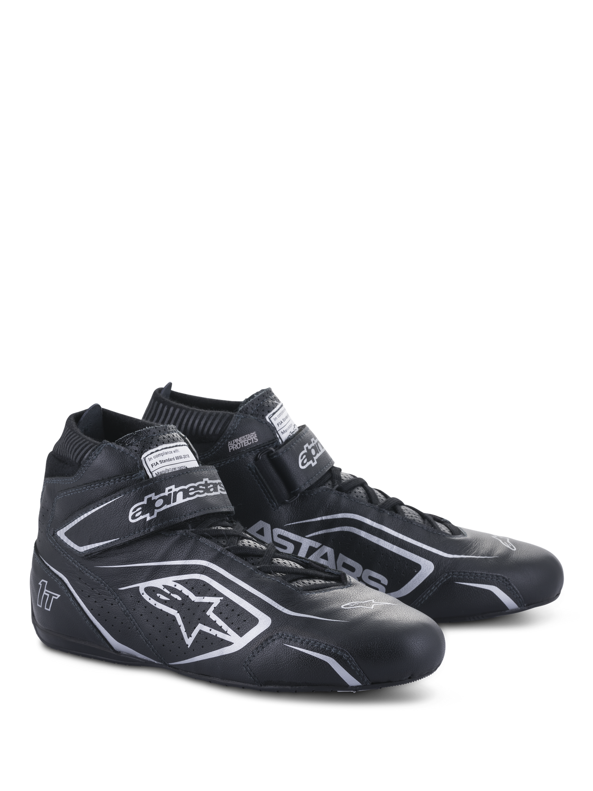 Alpinestars Tech-1 T V3 Schuhe FIA, Automobilsport-Schuhe, Schwarz und Silber, Rindslederkonstruktion mit silbernen Alpinestars-Logos und Branding, schräge Seitenansicht mit Klettverschluss und Schnürverschluss