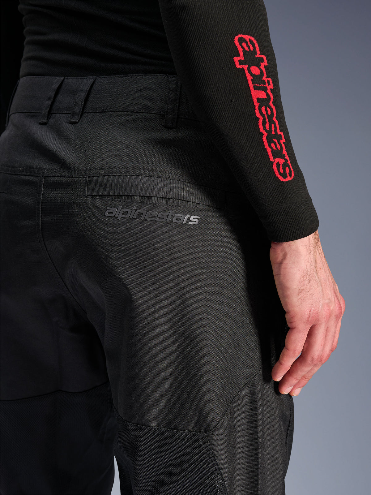 Alpinestars C-1 Air Hose, schwarze Textil-Motorradhose, Nahaufnahme der Gesäßtasche mit dezentem grauem Alpinestars-Logo, atmungsaktive Mesh-Einsätze und strapazierfähiges Polygewebe, entwickelt für urbanen Fahrkomfort
