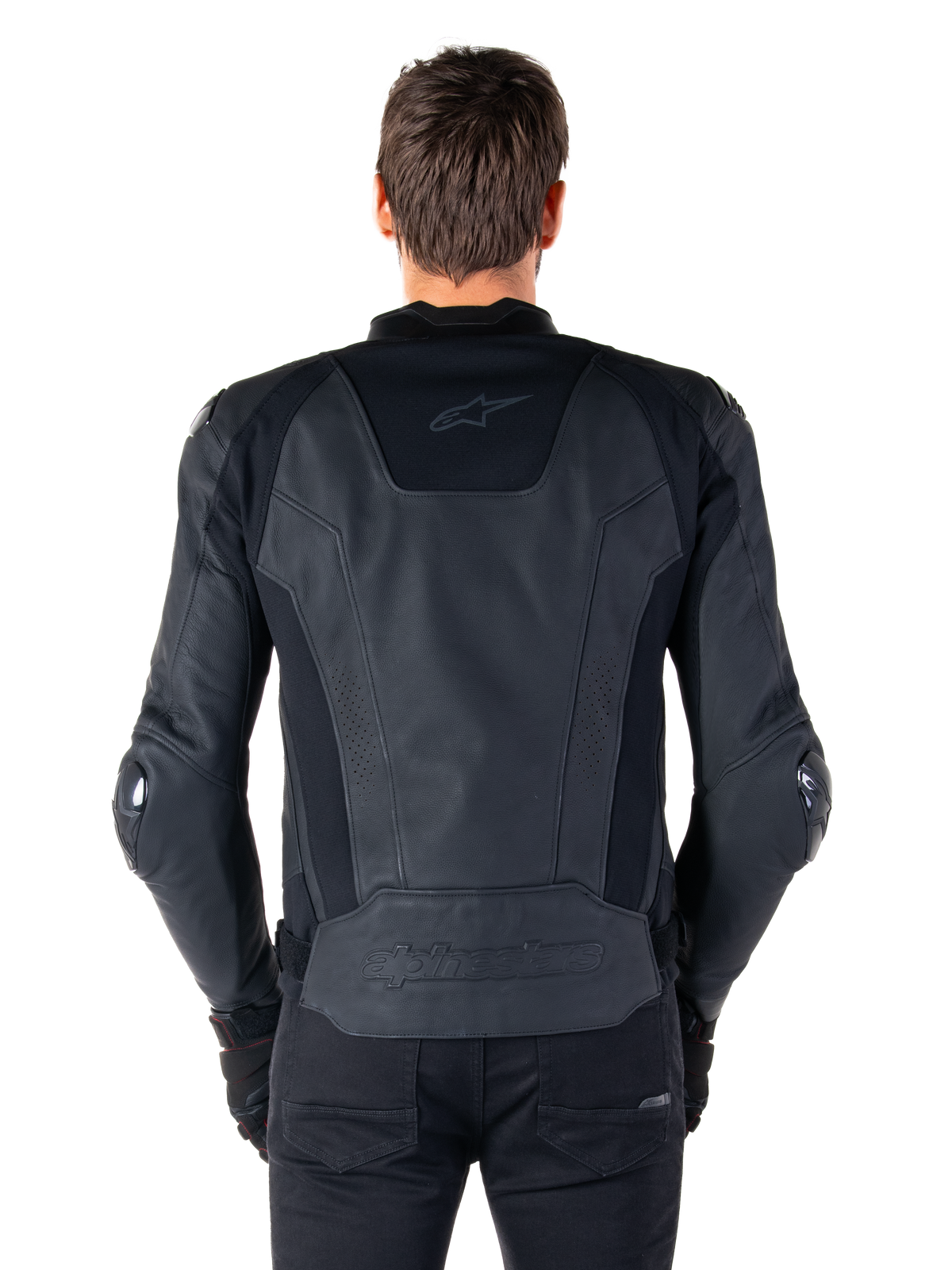 Rückansicht eines Fahrers, der die Alpinestars Missile V3 Lederjacke in Schwarz trägt, mit einer hochwertigen Lederkonstruktion, technischen Stretch-Einsätzen, geprägtem Alpinestars-Logo am unteren Rücken und dezentem Branding am oberen Rücken, kombiniert mit einer schwarzen Hose für einen abgestimmten Racing-Sport-Look.