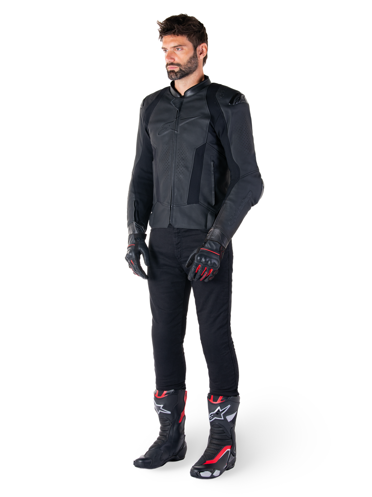 Alpinestars Missile V3 Lederjacke, Schwarz, getragen von einem Fahrer mit schwarzer Hose sowie schwarz-roten Rennsport-Handschuhen und Stiefeln, mit perforierten Ledereinsätzen und elegantem, monochromem Branding, professionelle Rennsport-Ästhetik