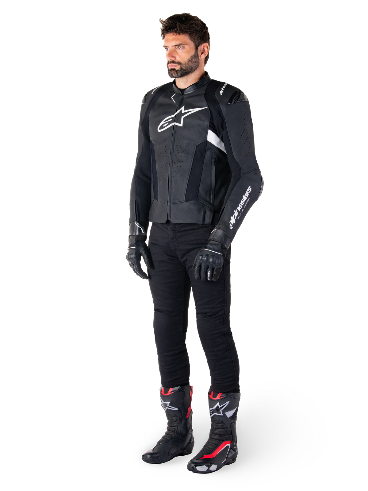 Male rider wearing the Alpinestars Missile V3 Leather Jacket in Black and White, featuring a white chest logo and perforated leather panels, paired with black riding pants, black gloves, and black and red racing boots for a complete sport riding look.